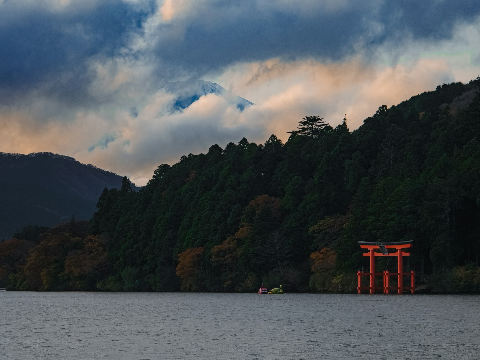 Pemandangan indah dari gerbang torii merah dekat danau dikelilingi gunung