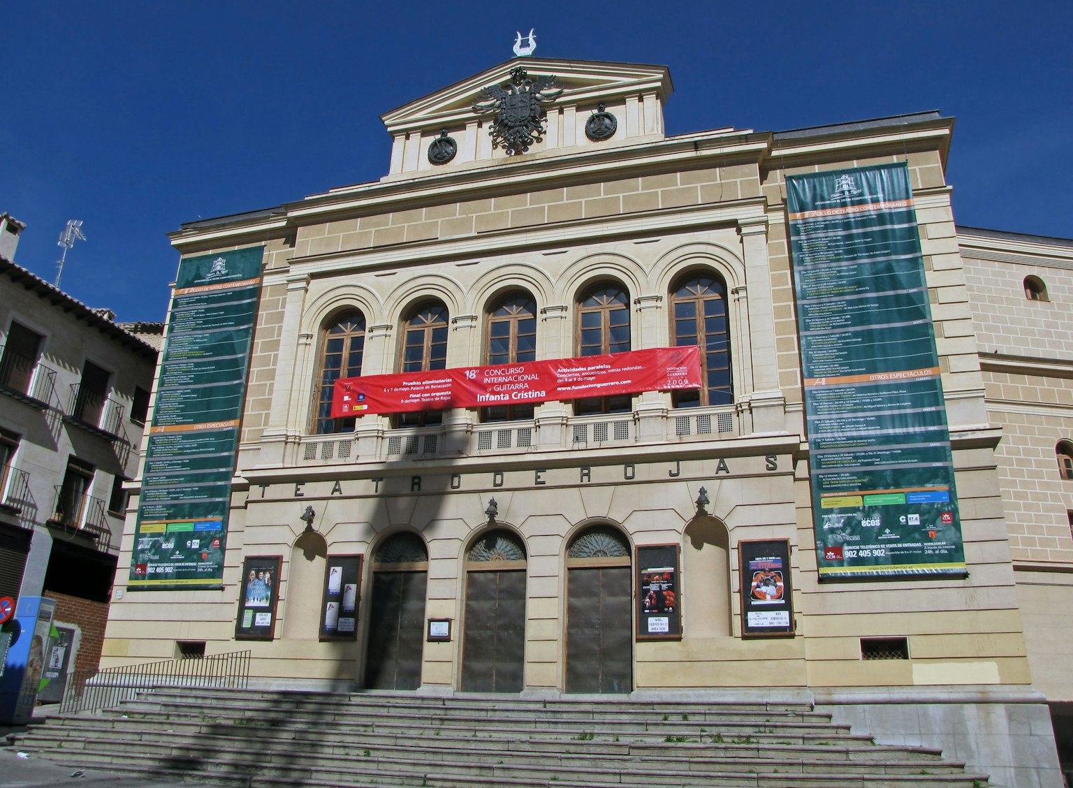 Fasad teater bersejarah dengan spanduk merah