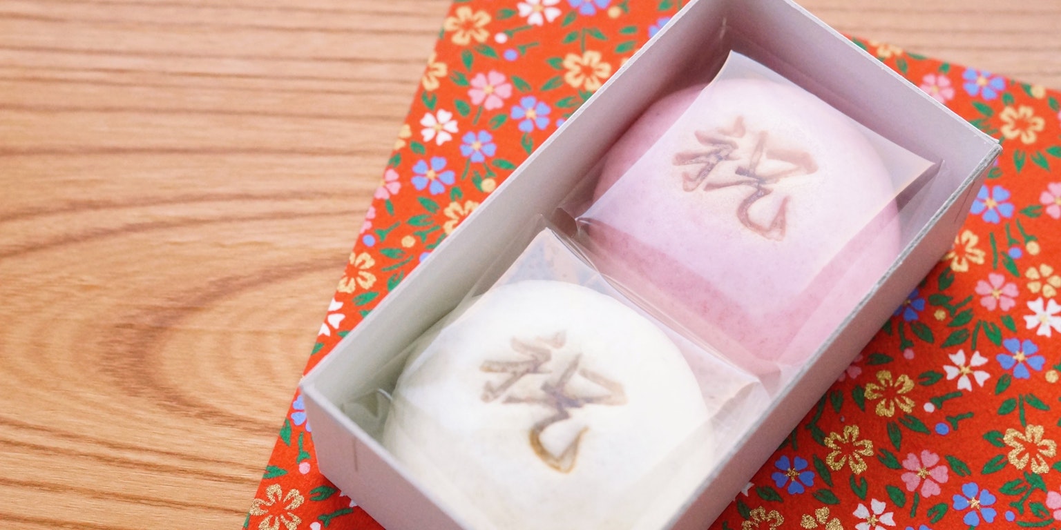 Scatola di dolci giapponesi tradizionali con manju rosa e bianco