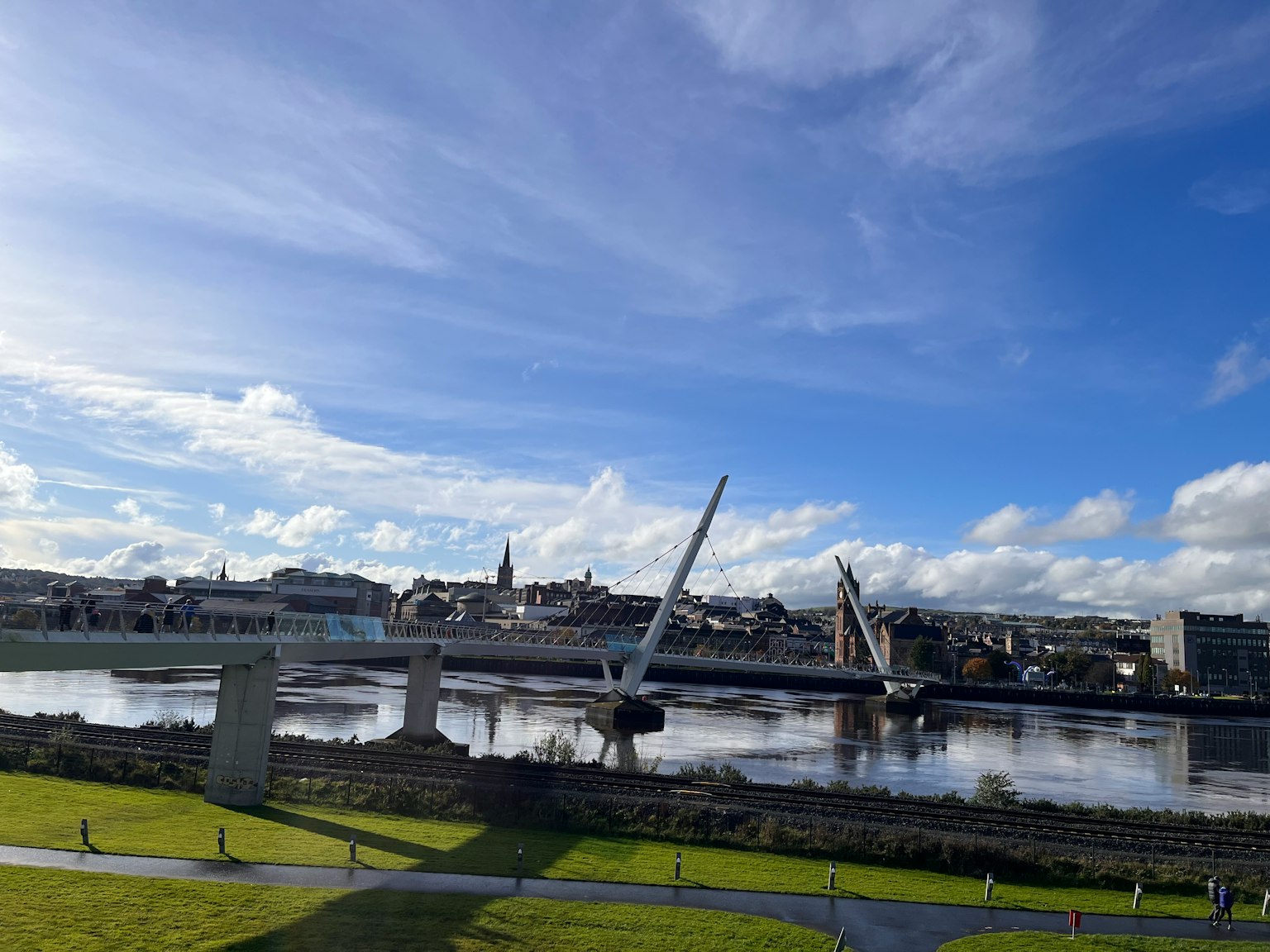 Paysage avec un pont incliné au-dessus d'une rivière sous un ciel bleu