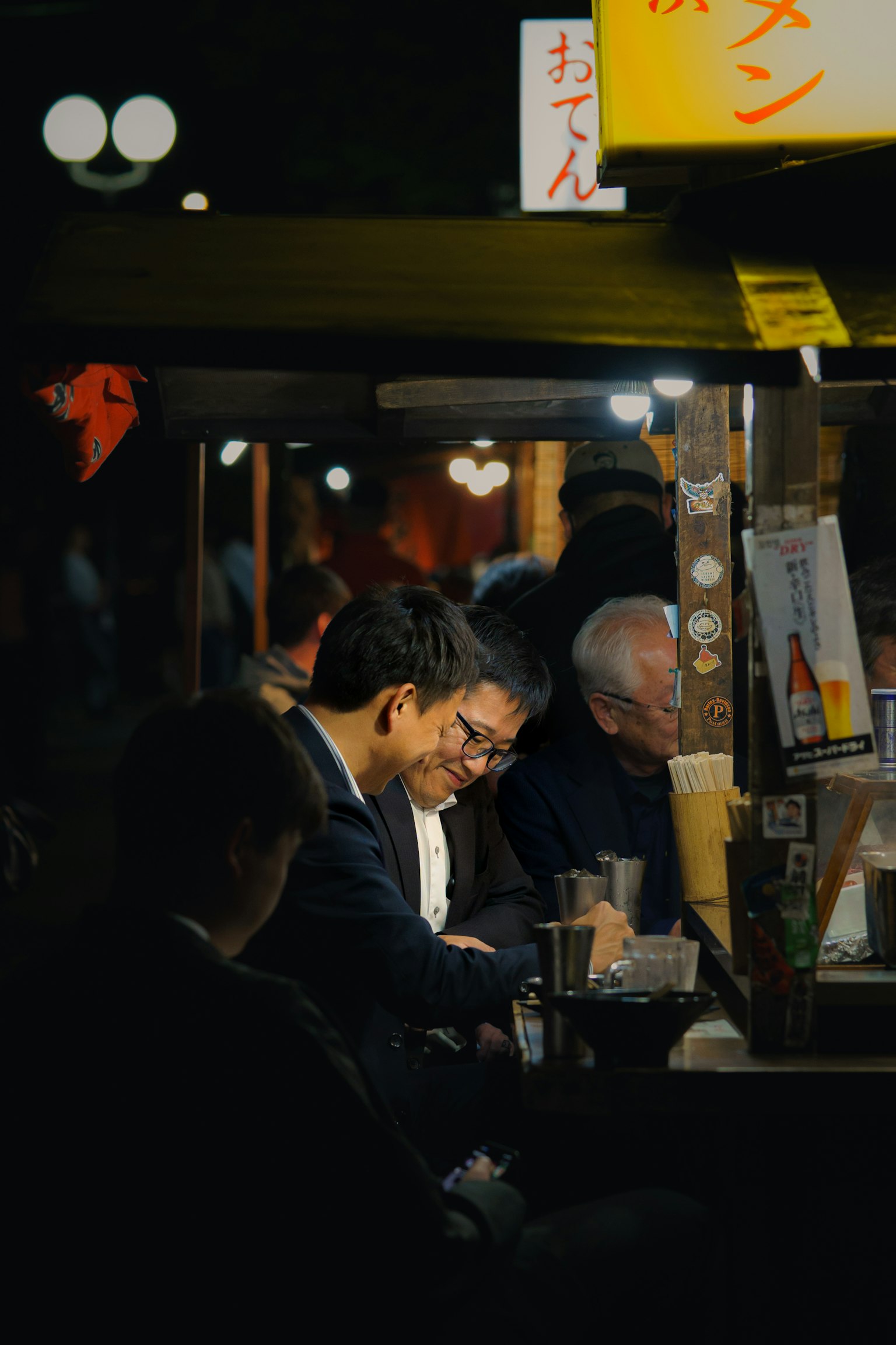 Menschen genießen Essen an einem Nachtmarkstand mit warmer Atmosphäre
