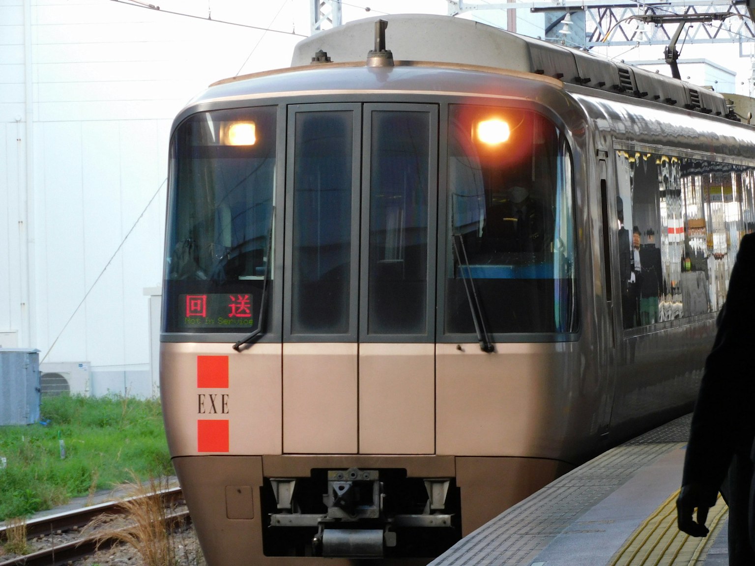 มุมมองด้านหน้าของรถไฟสีน้ำตาลที่จอดอยู่ที่สถานี