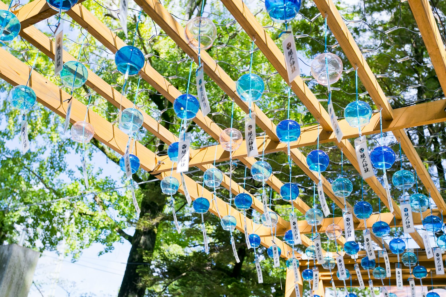 Un paisaje con campanas de viento azules colgando de una estructura de madera