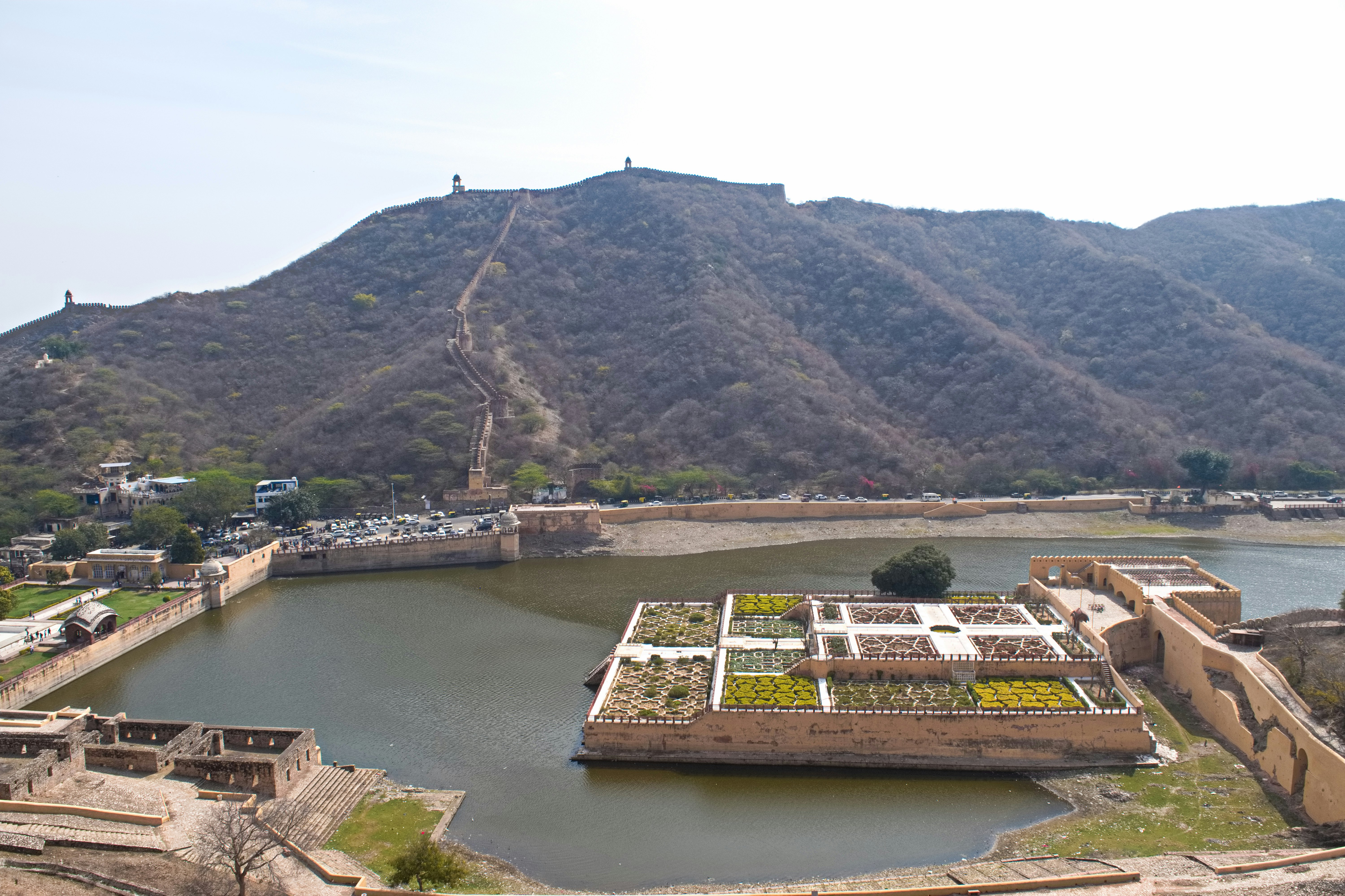 vista de un castillo junto al río y sus jardines al pie de la montaña