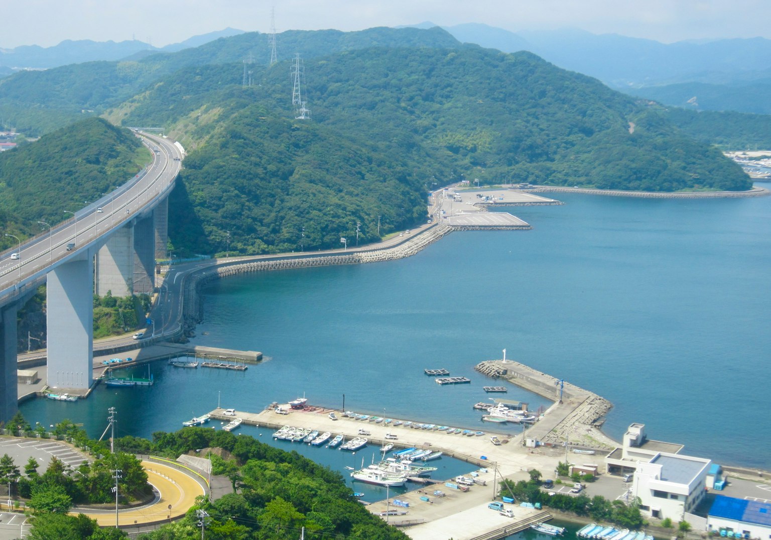 Vue pittoresque d'un pont et d'un port entourés de montagnes verdoyantes et d'eau
