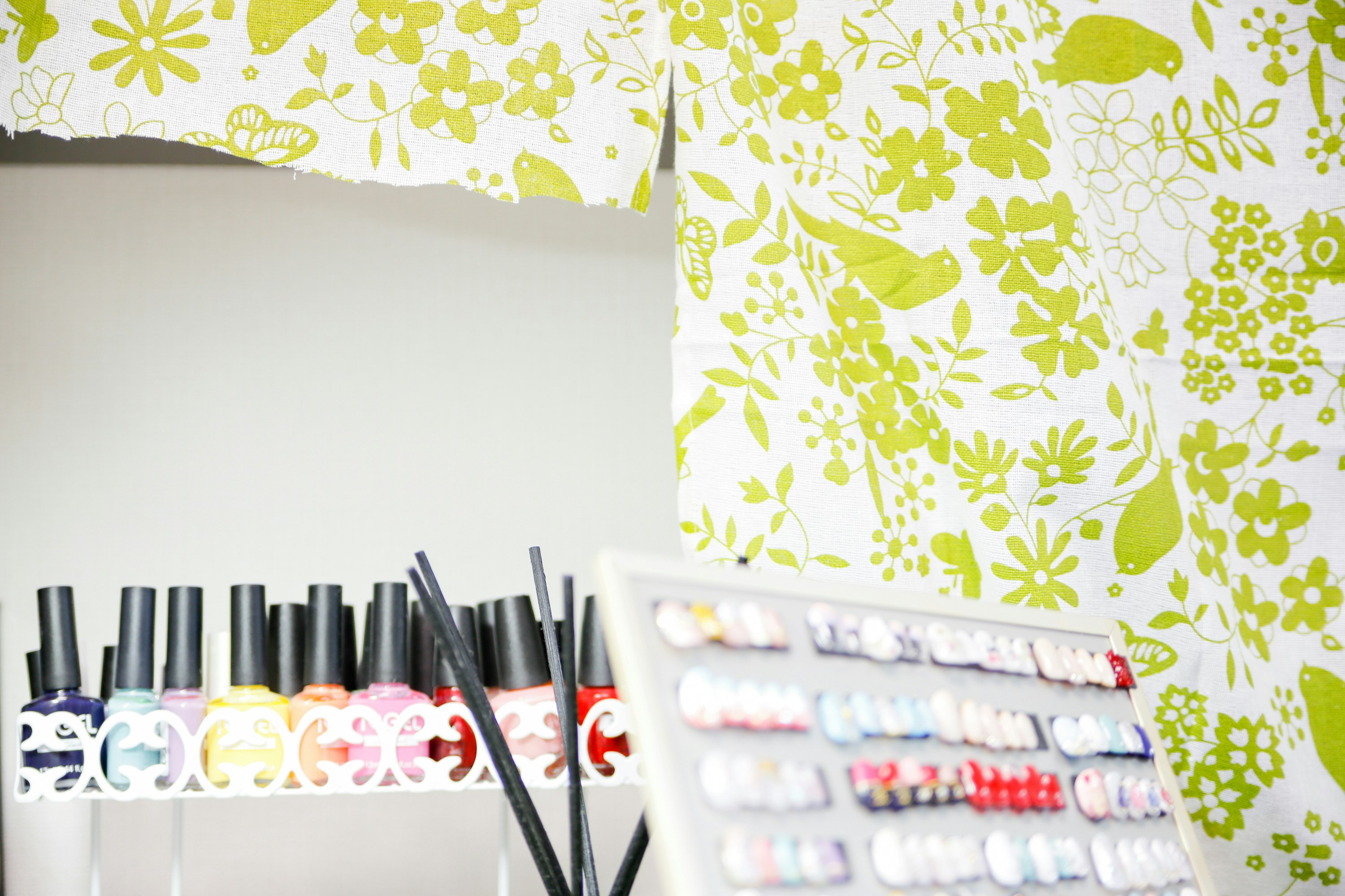 Présentoir de brosses à dents et de dentifrice devant un mur fleuri