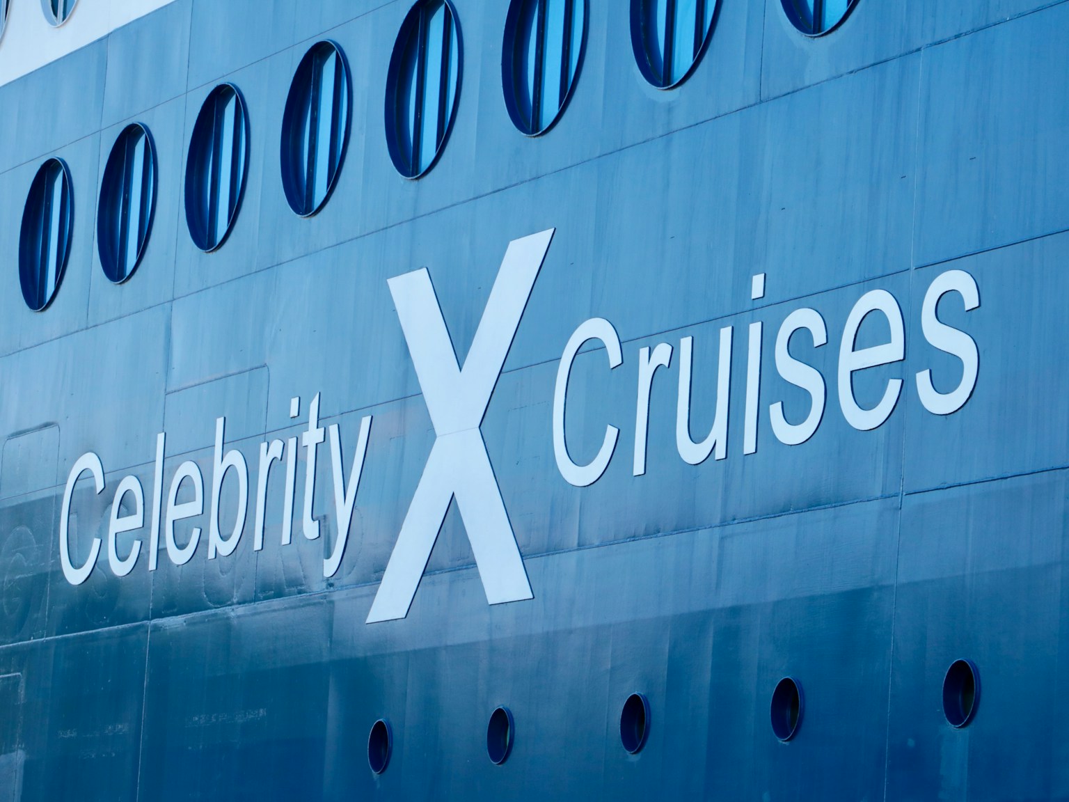 Sisi kapal pesiar yang menampilkan logo Celebrity X Cruises