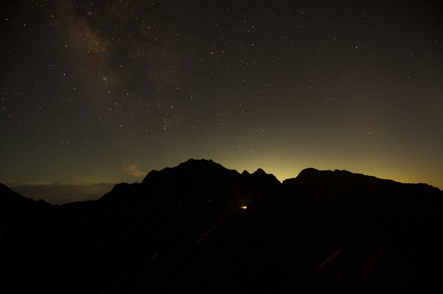 Nachtlandschaft mit Silhouetten von Bergen unter einem Sternenhimmel
