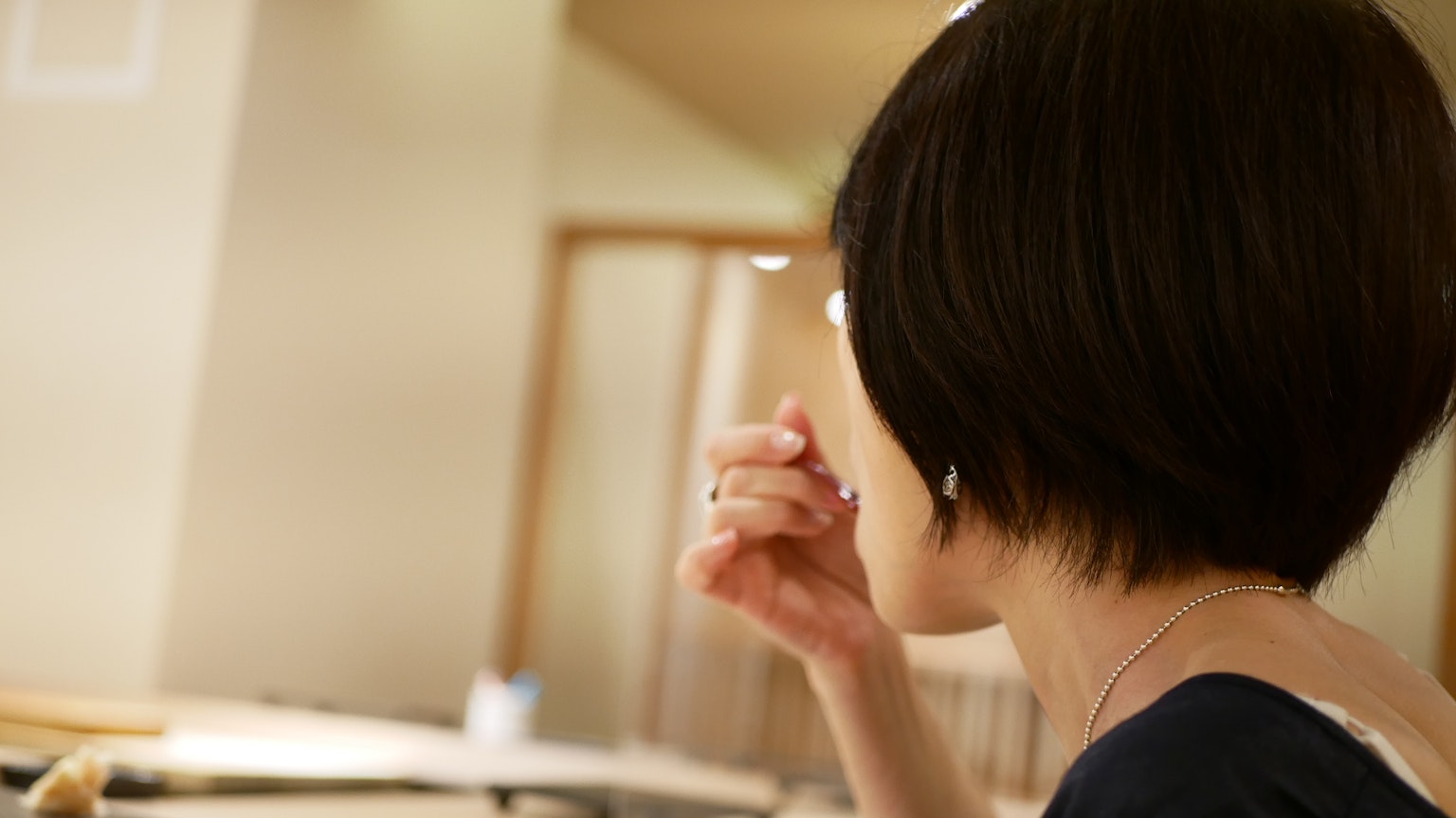 A woman eating in a restaurant with a warm interior