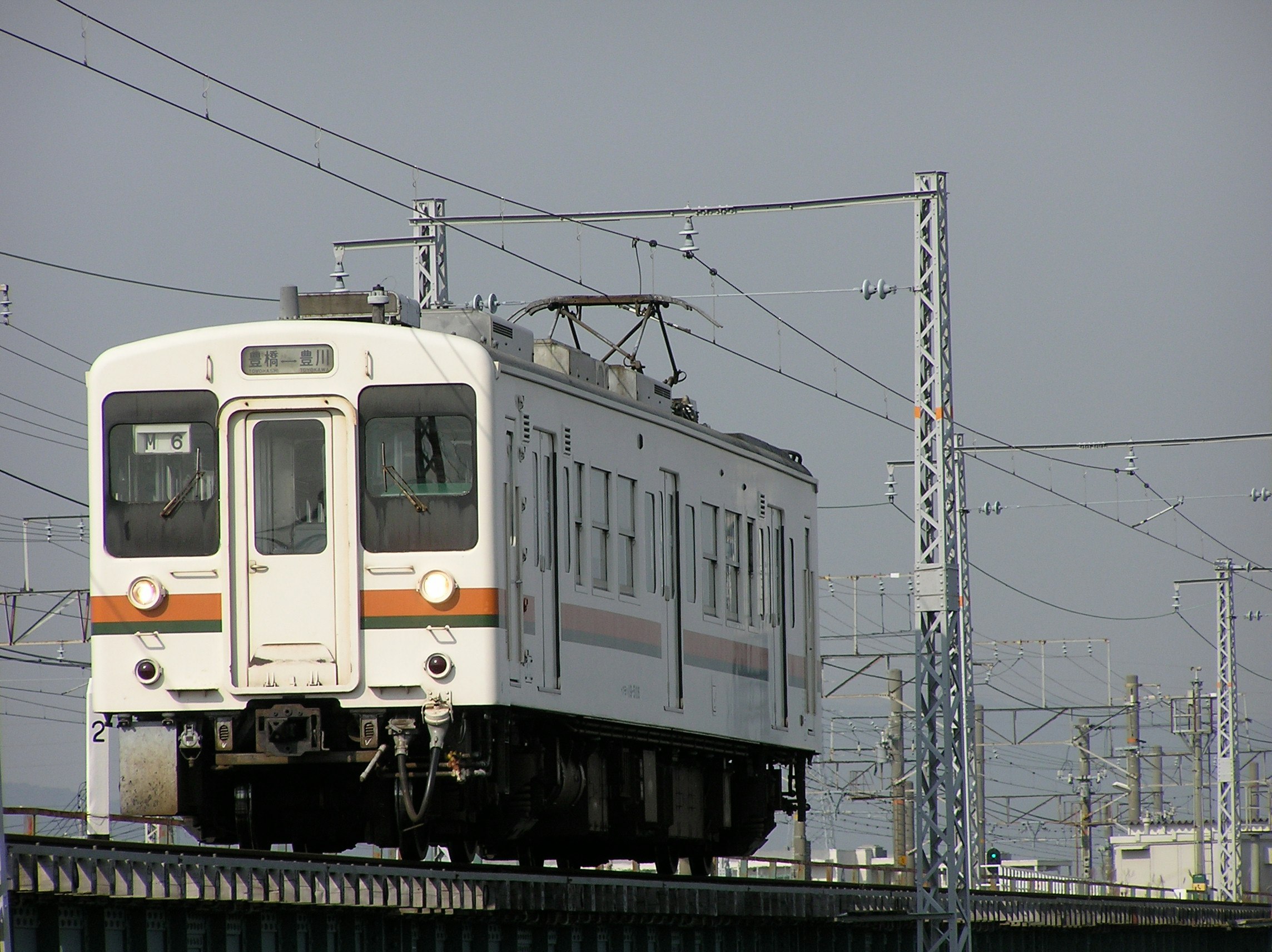電車が架線のある高架線路を走る風景