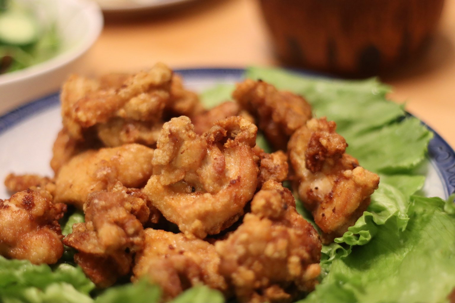 Potongan ayam goreng renyah disajikan di atas selada segar