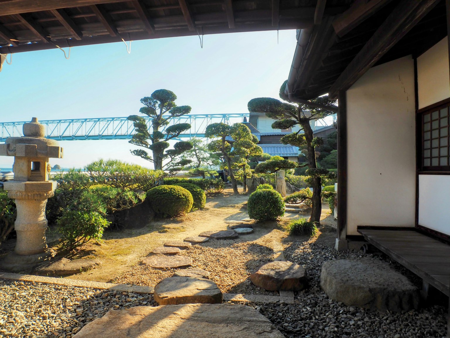 View of a traditional Japanese garden with stone lantern and manicured plants