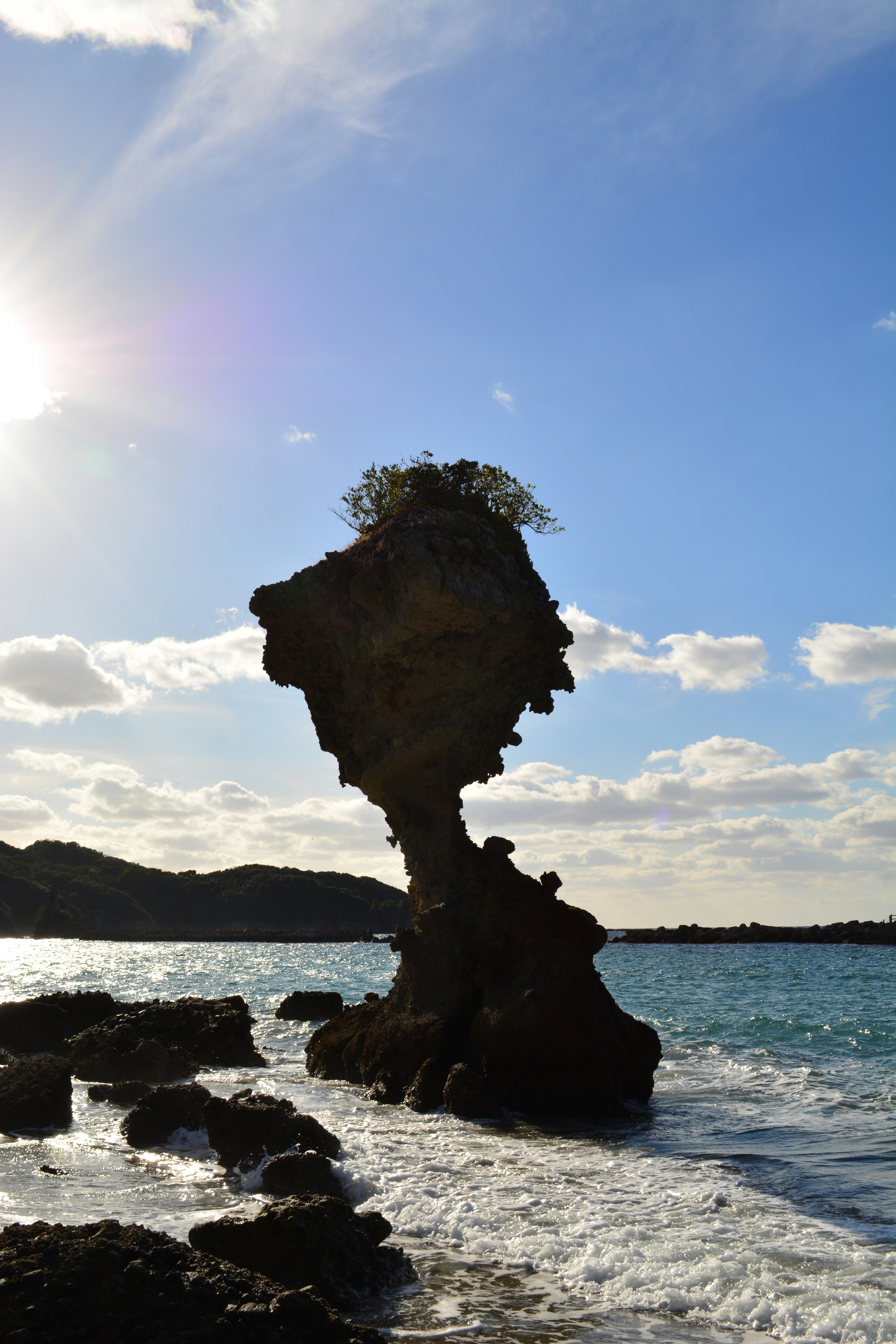 rock formation on a seaside shore under a blue sky