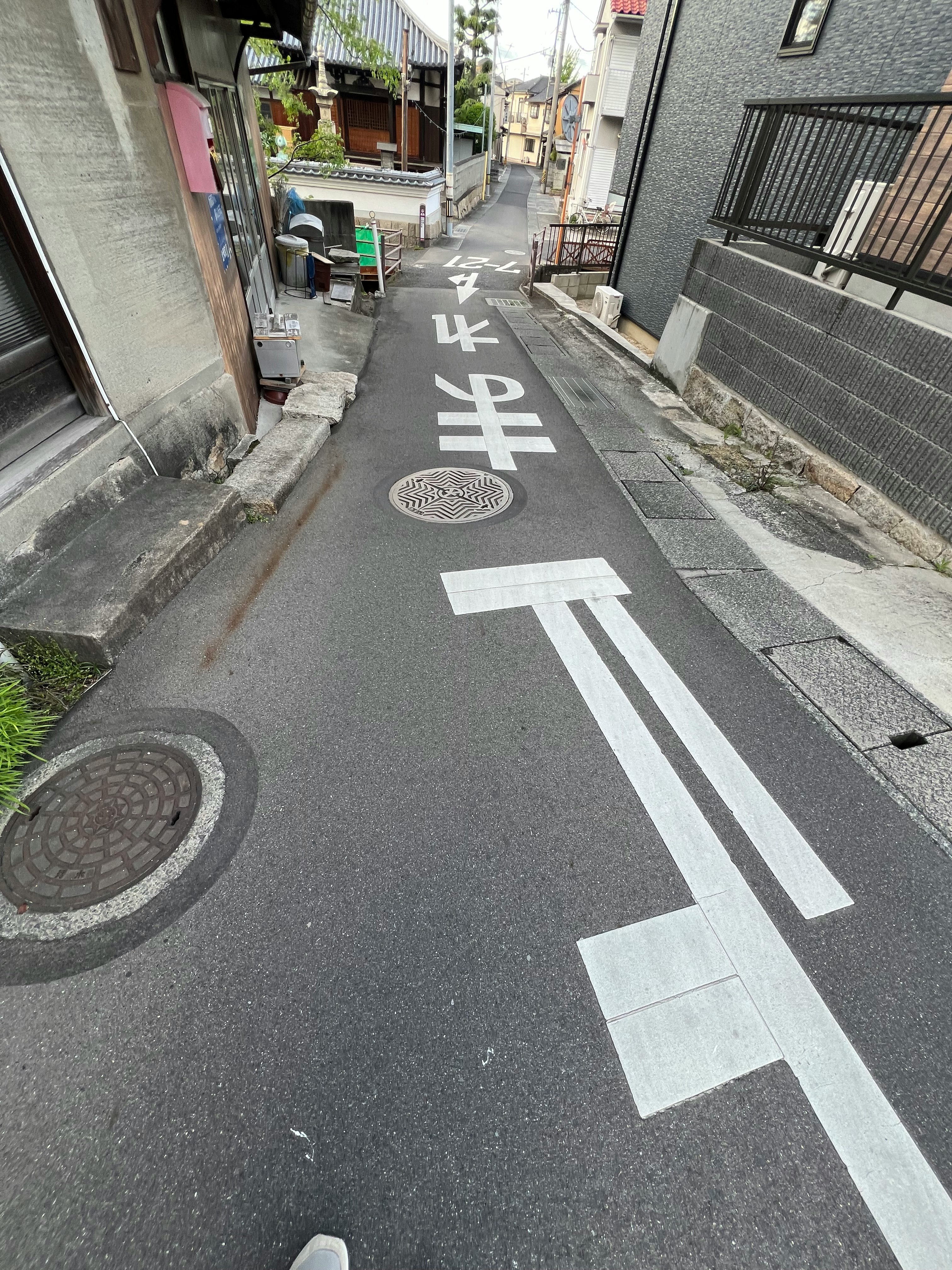 路地の一旦停止標識と横断表示のある狭い通り