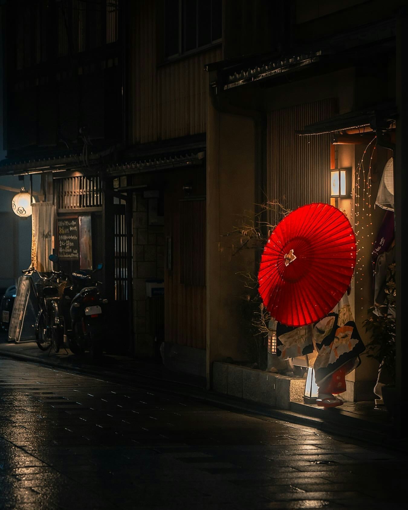 夜晚小巷店铺门口的红色灯笼与自行车