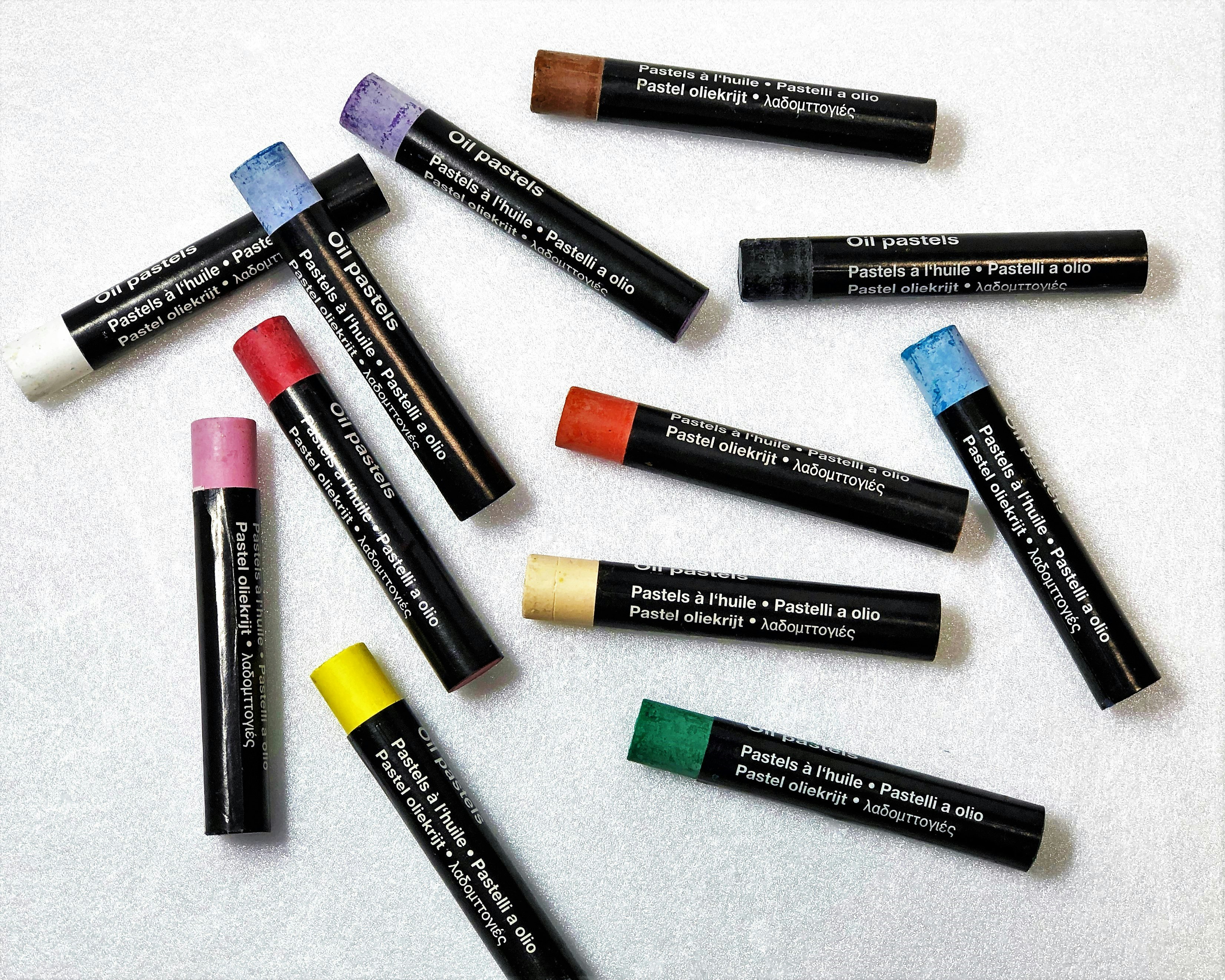 Pastel-colored oil pastels arranged on a white surface