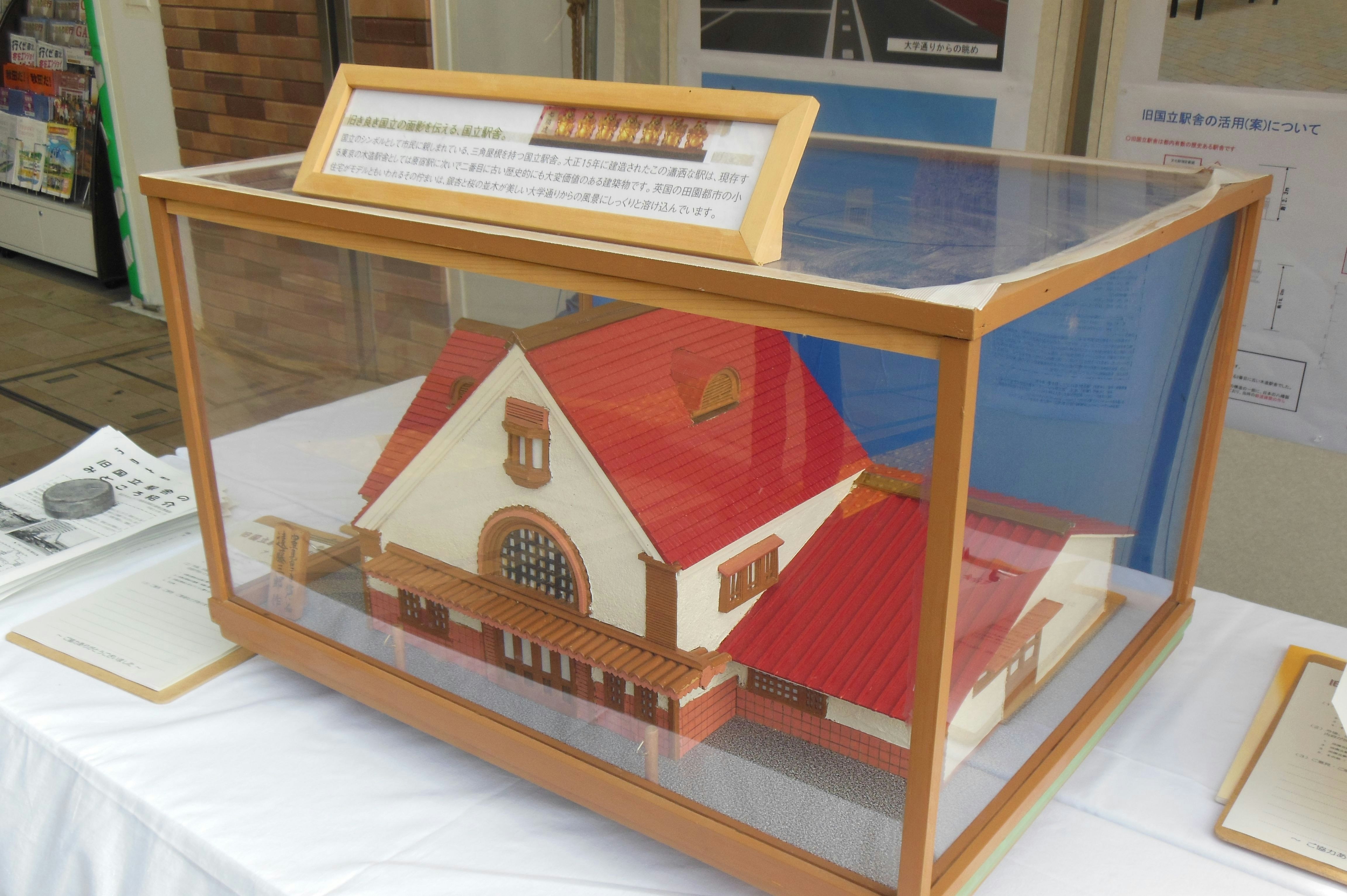 展示台の上に置かれた模型の家と建物パネル