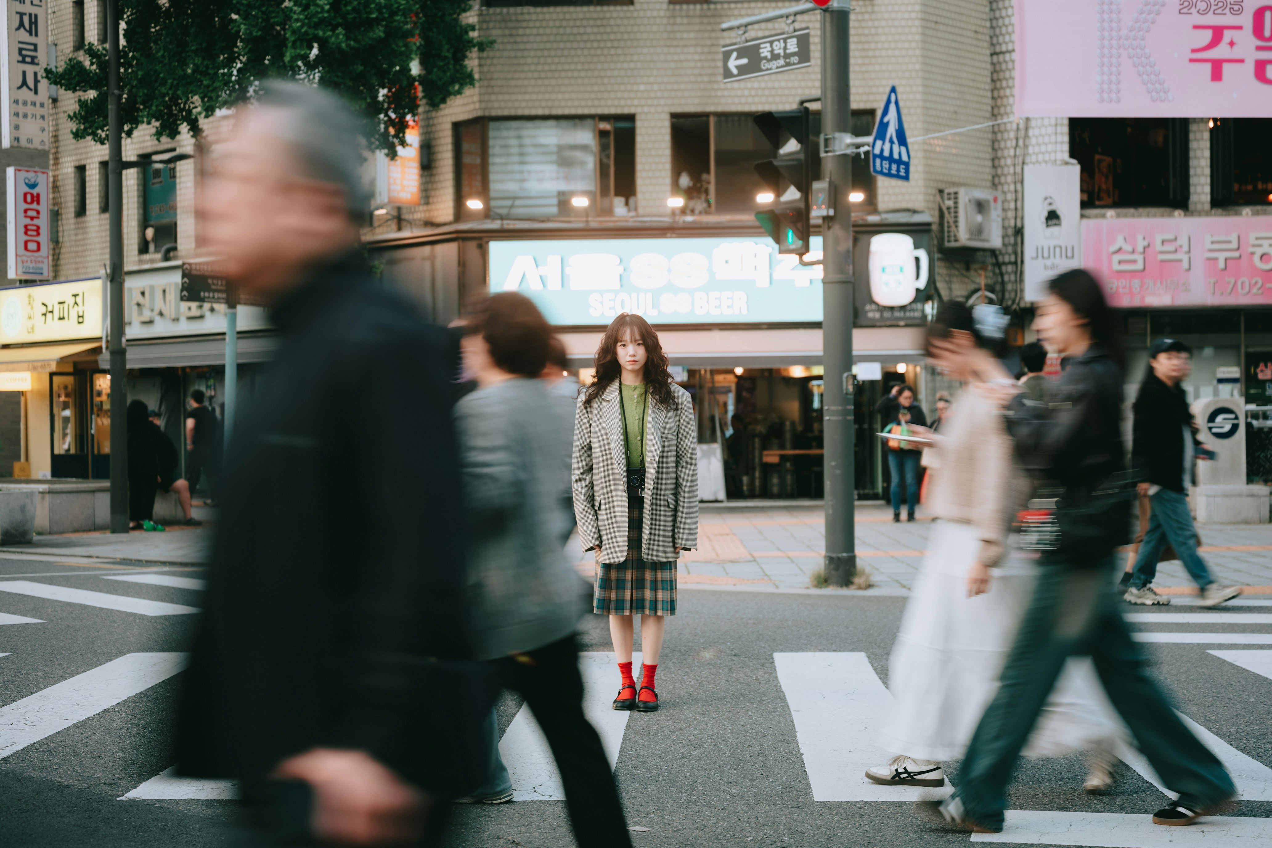 横断歩道を歩く人々がいる街角の風景