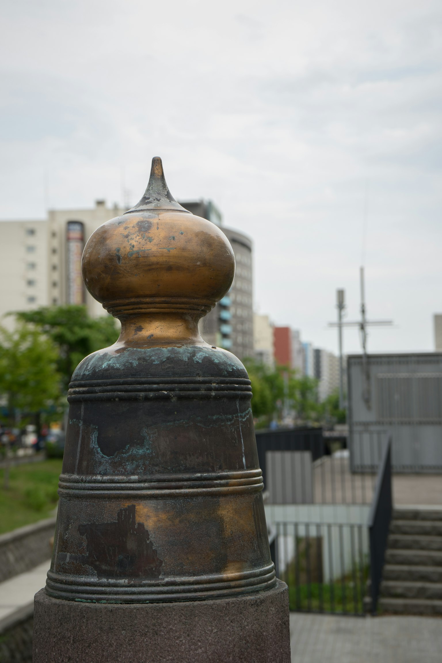 金属物体的特写，上方有圆形元素 背景中可见城市建筑