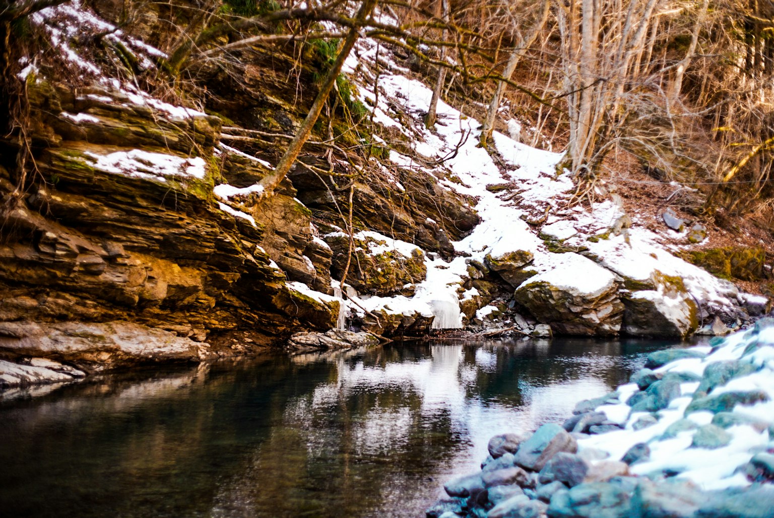 雪覆盖岩石和平静水面的河流景观