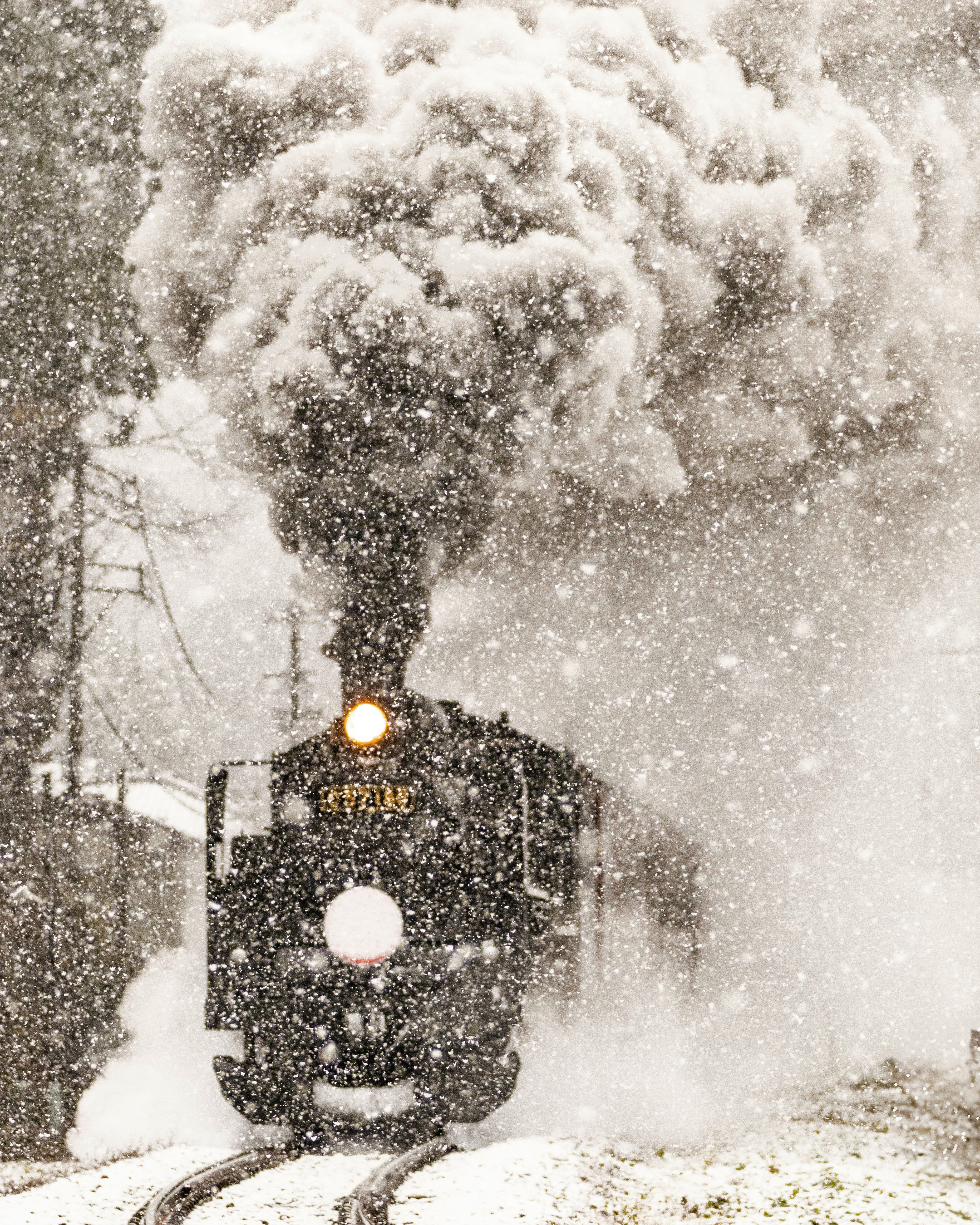 雪煙の中を走る列車の正面