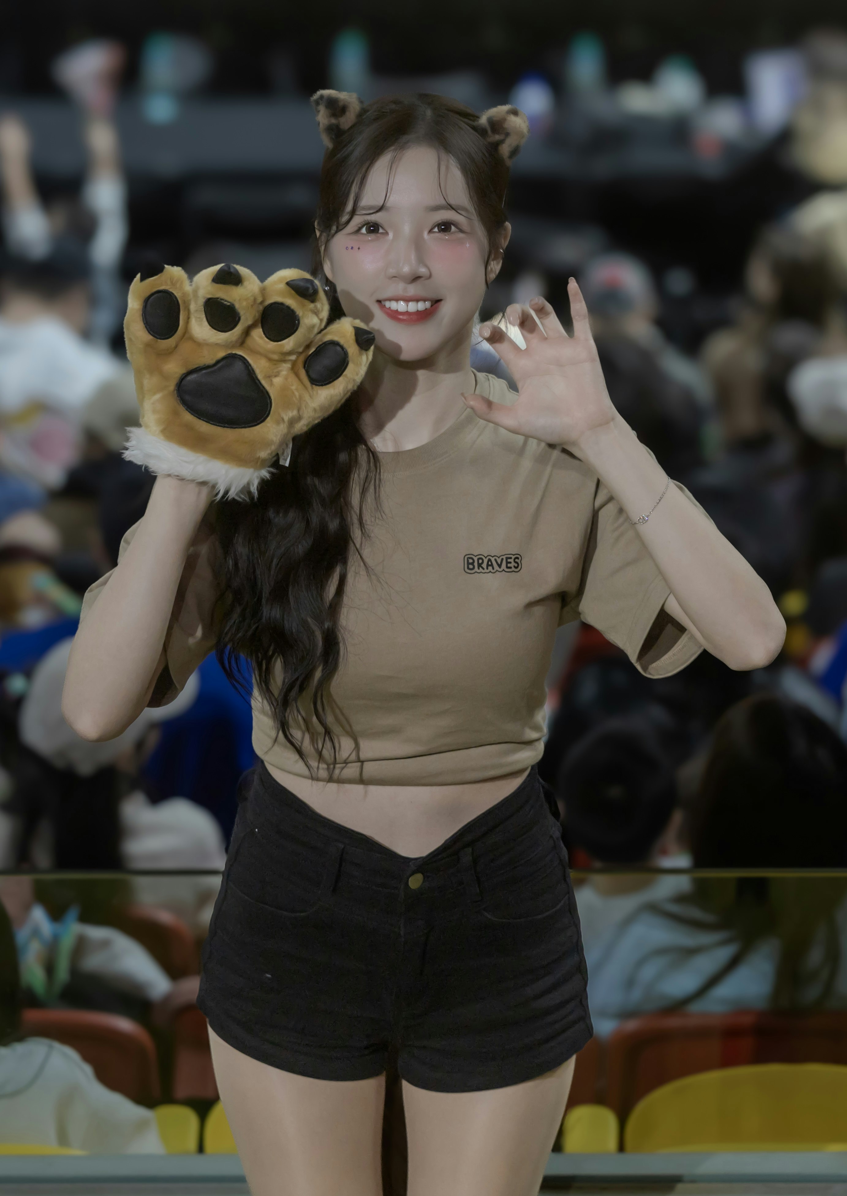 wanita tersenyum memakai headband maskot anjing di stadion