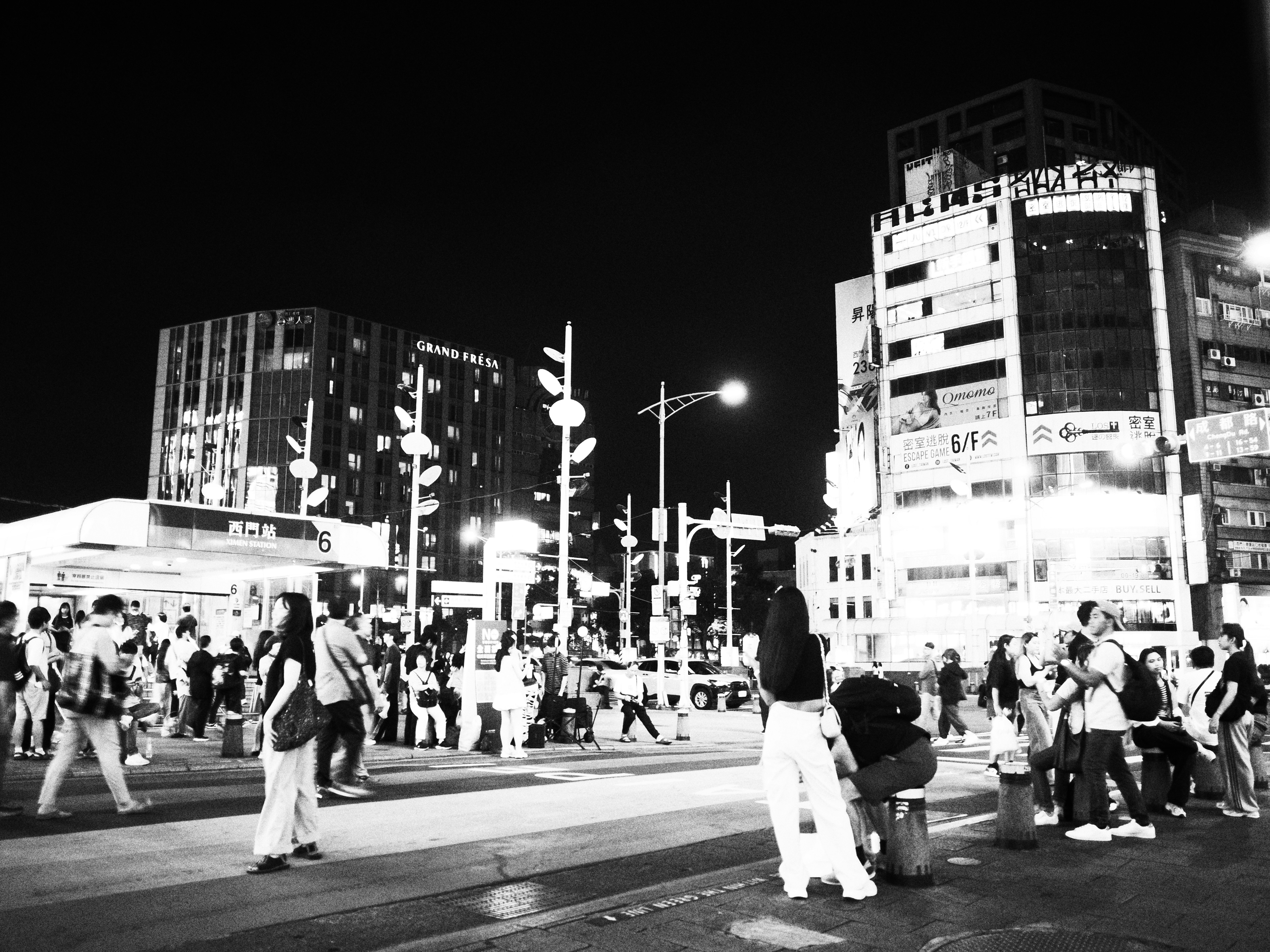 夜の台北の交差点で人々が行き交う街並み