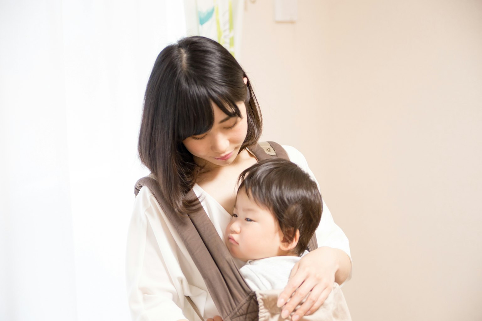 A mother holding her child in a soft indoor setting
