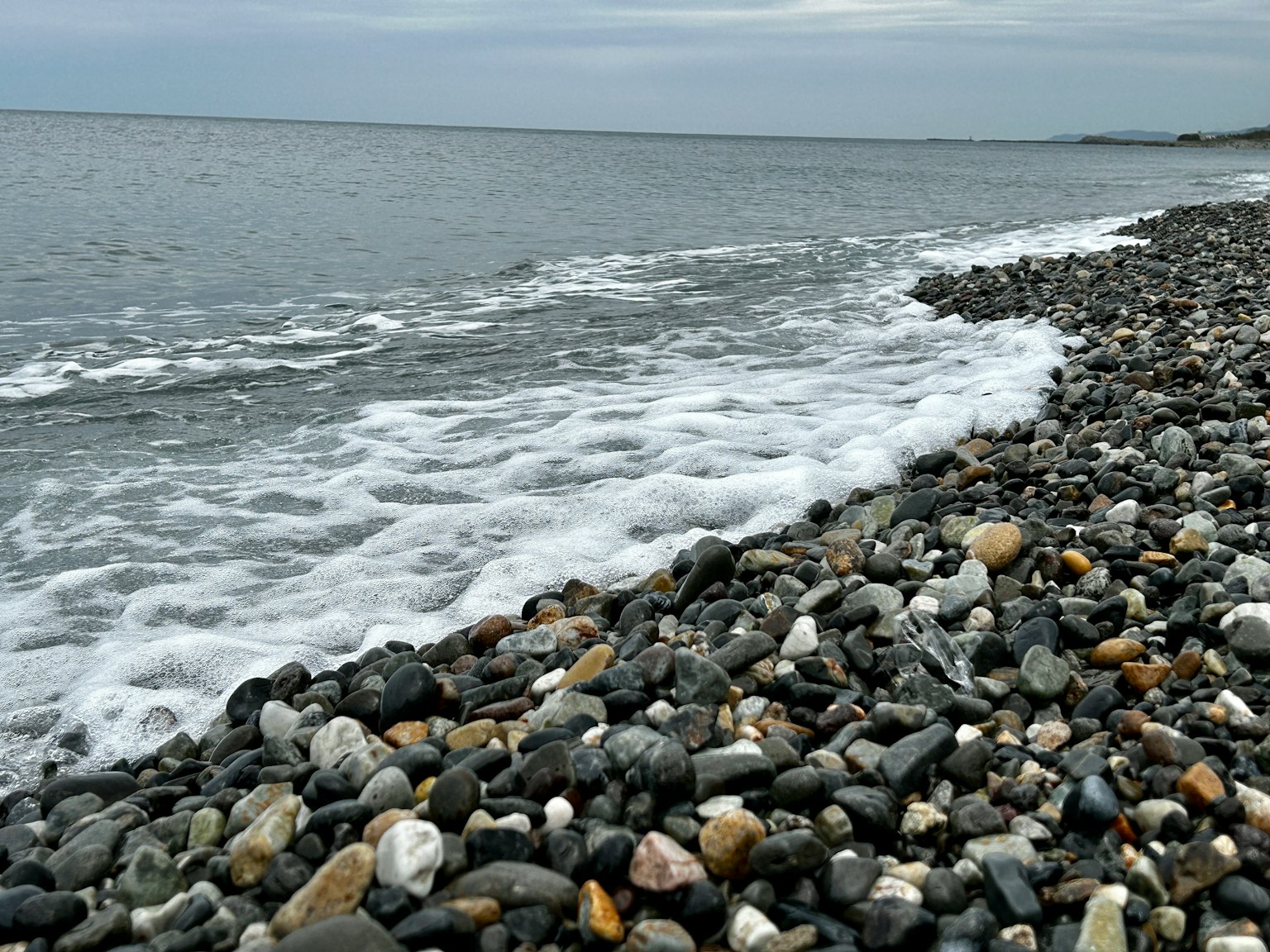 Playa rocosa con olas que llegan a la orilla