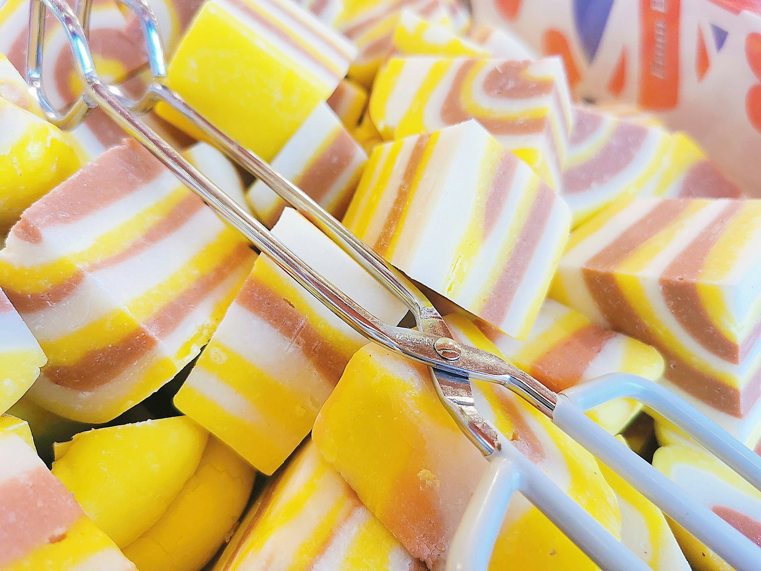 Bunte Bonbons in einem Korb mit silbernen Zangen