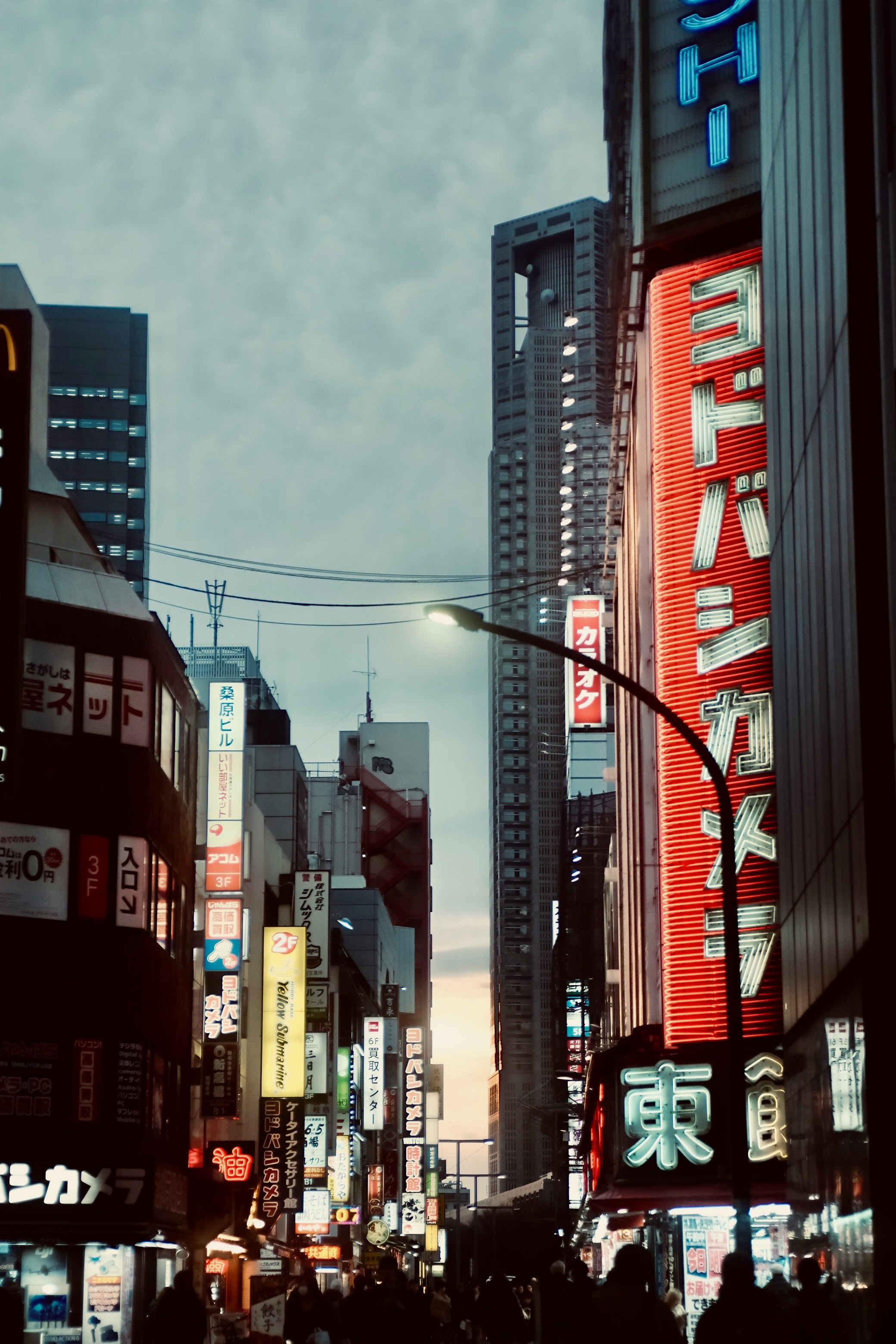 neon signs lining a busy city street at dusk