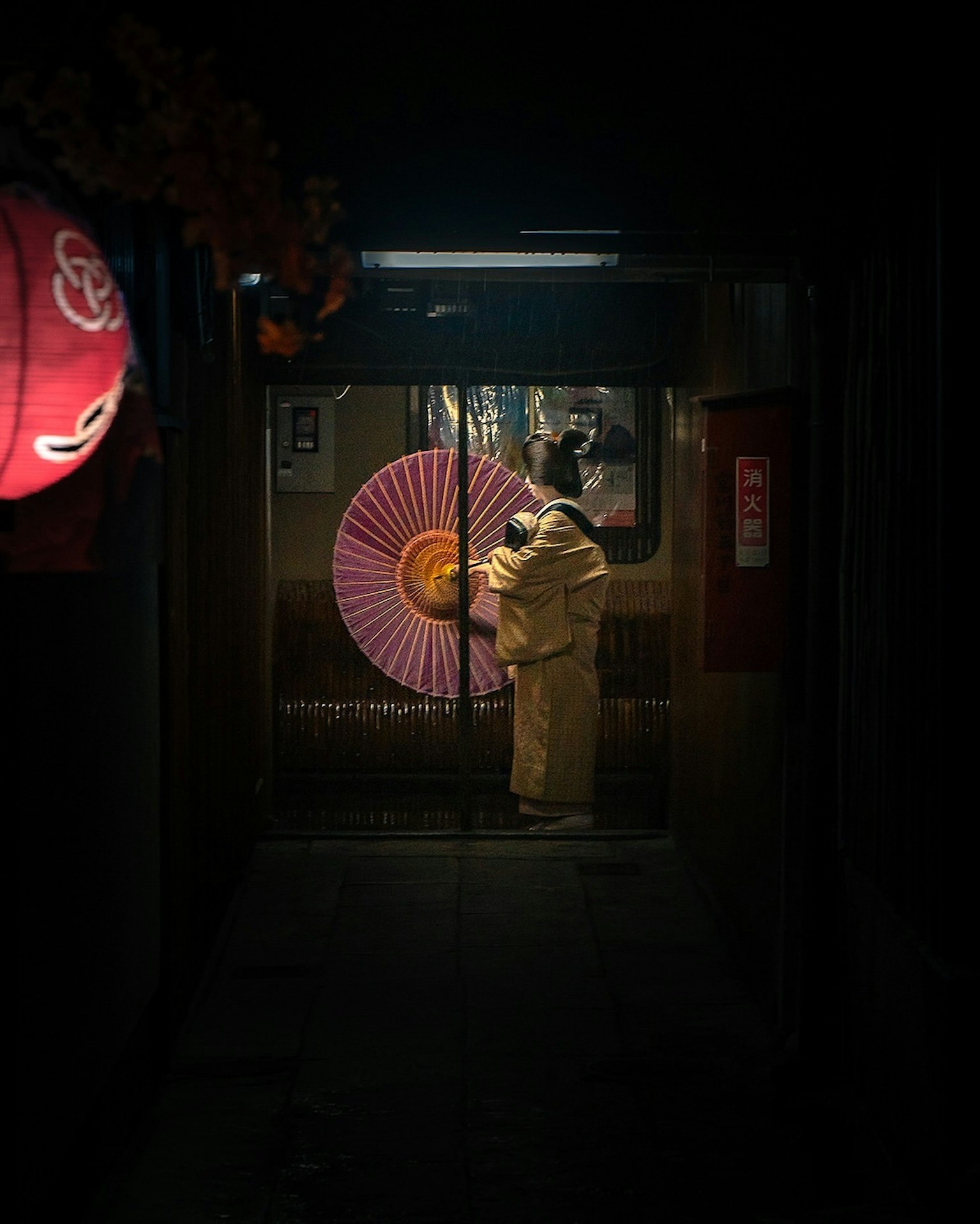 Người phụ nữ mặc kimono cầm ô truyền thống trong hẻm tối tăm