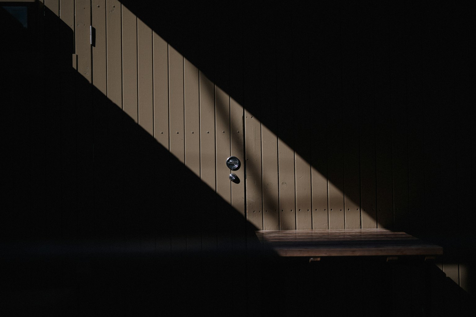 Una imagen impactante de una puerta iluminada por la luz sobre un fondo oscuro