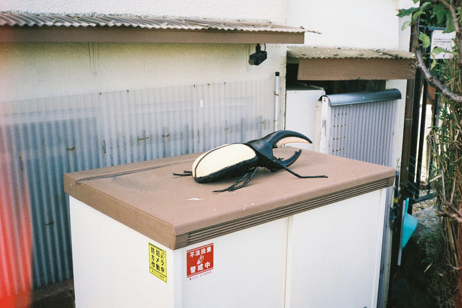 Un objet ressemblant à un insecte noir et blanc sur un réfrigérateur extérieur