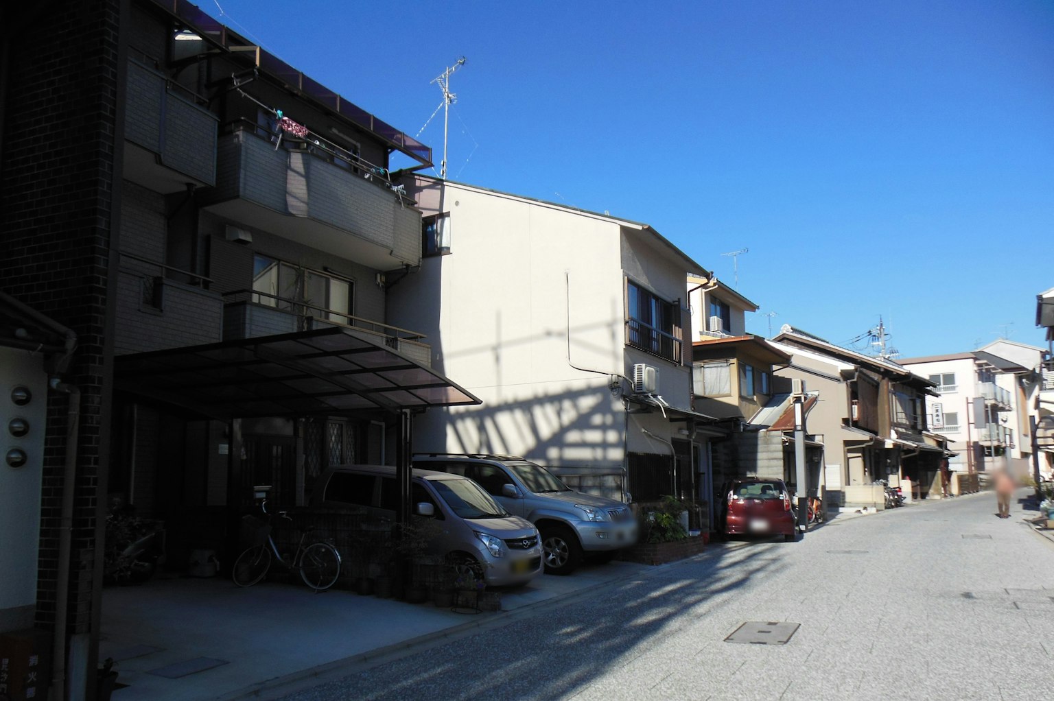 Scena di strada residenziale tranquilla con più case e cielo blu sereno