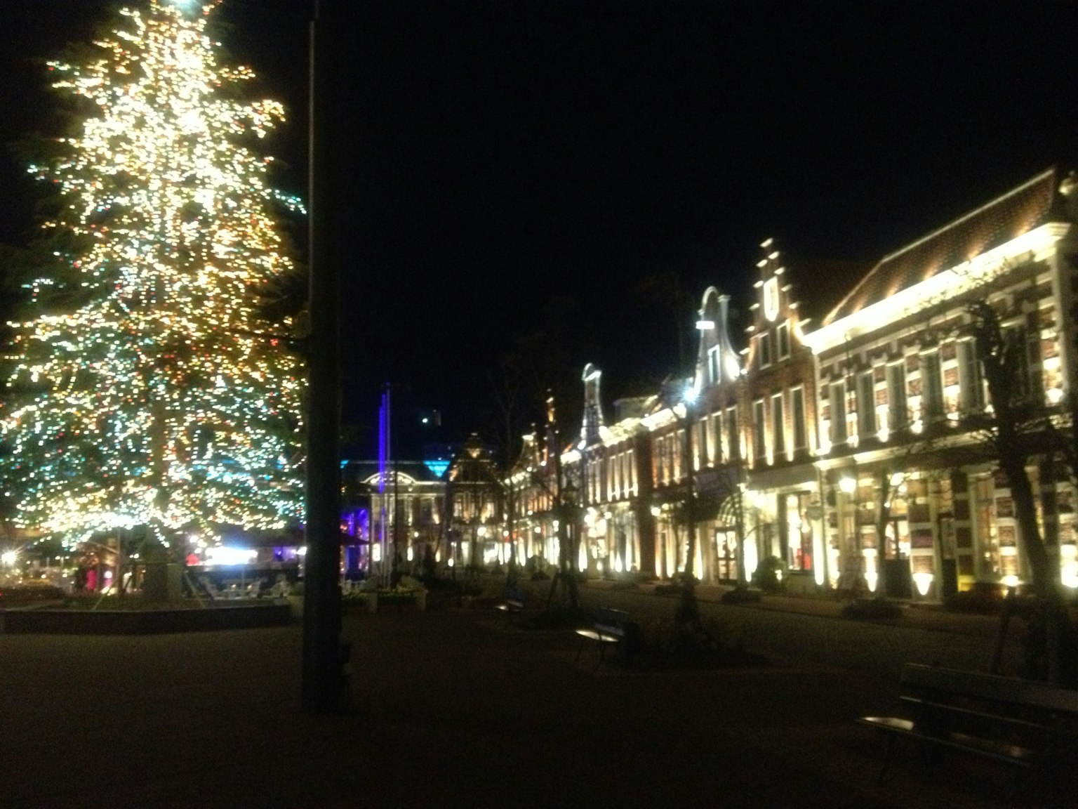 Scène de rue illuminée avec un arbre de Noël la nuit