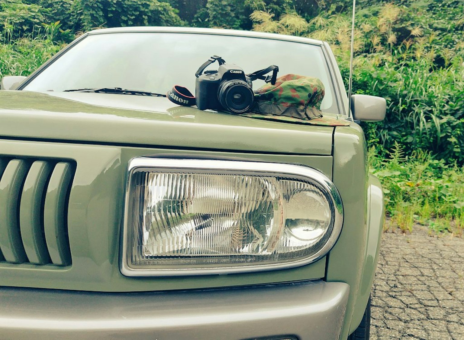 Kap mesin mobil hijau dengan kamera dan aksesori di atasnya