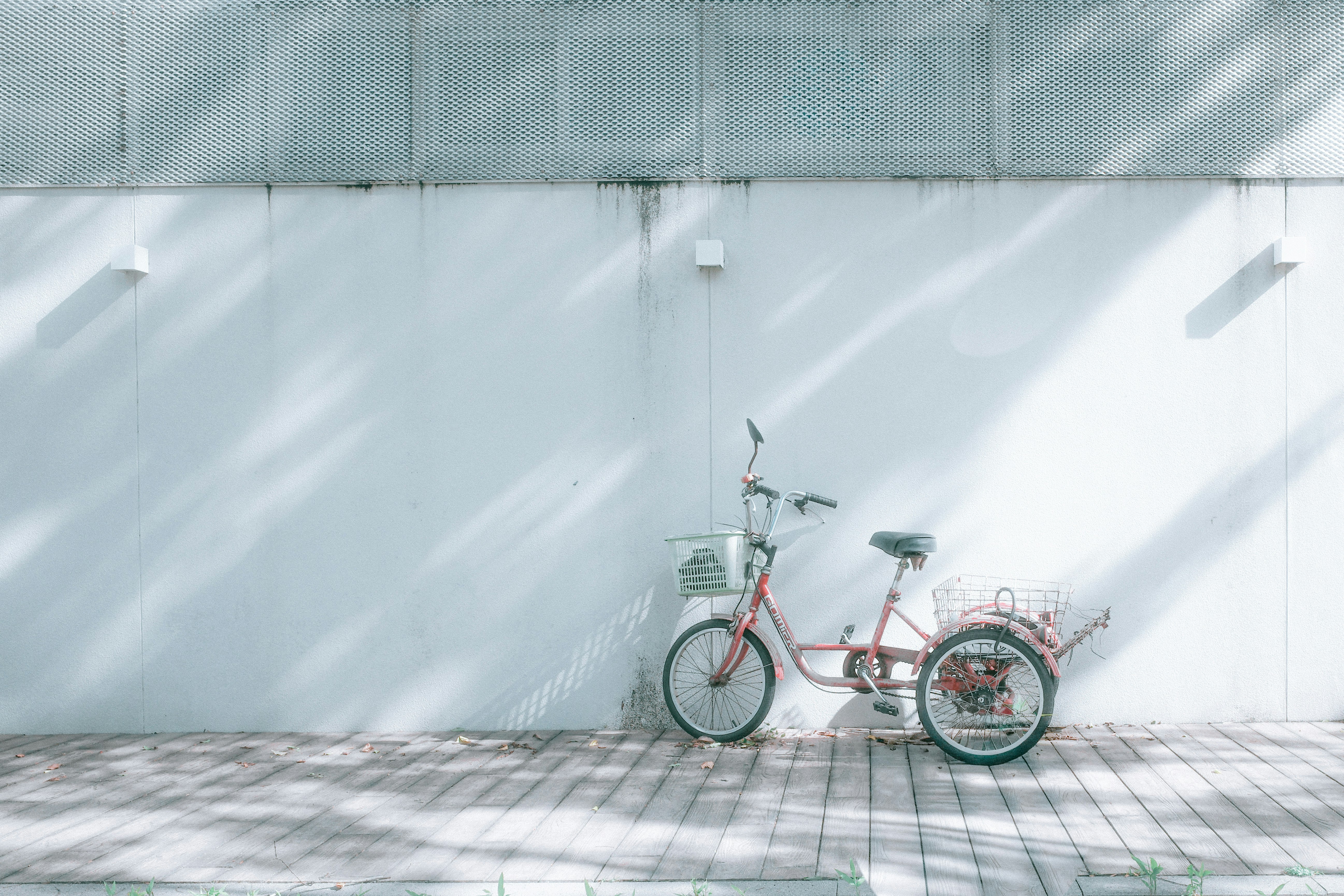 白い壁の前に並ぶ赤い自転車