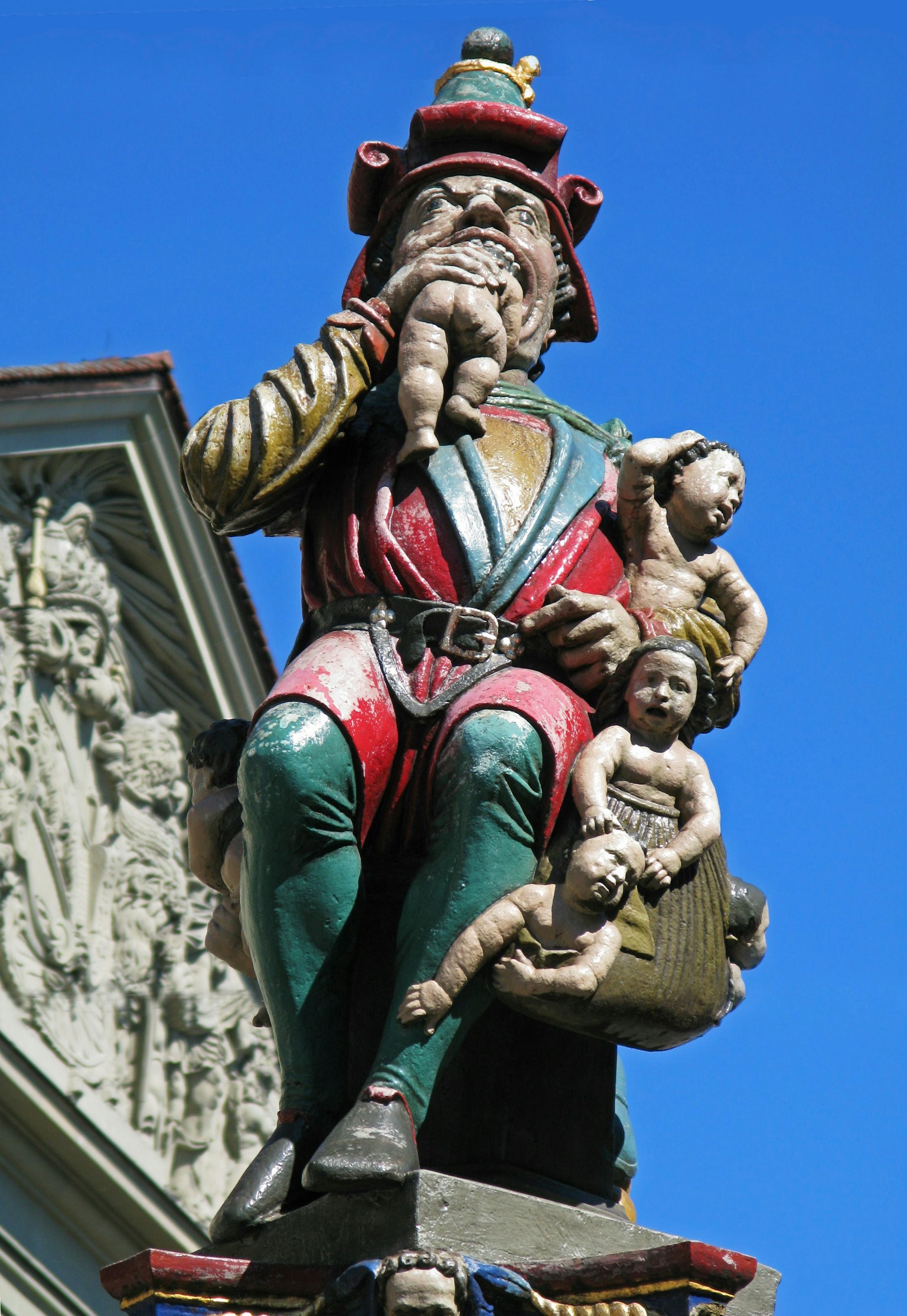 Estatua colorida de un hombre sosteniendo niños