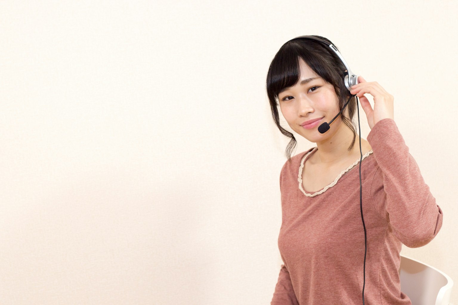A smiling woman wearing a headset