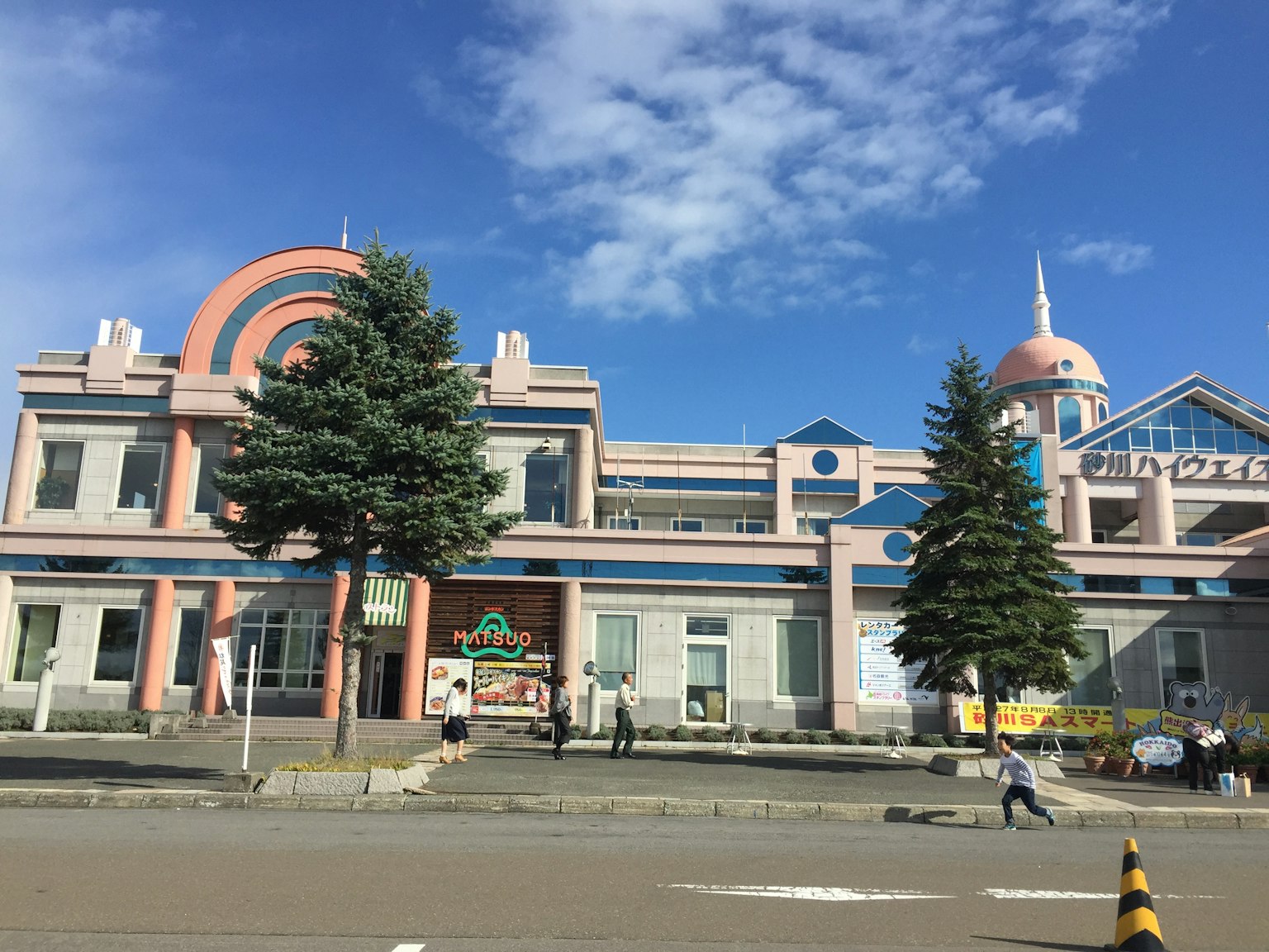 Edificio dal design distintivo con alberi sotto un cielo blu