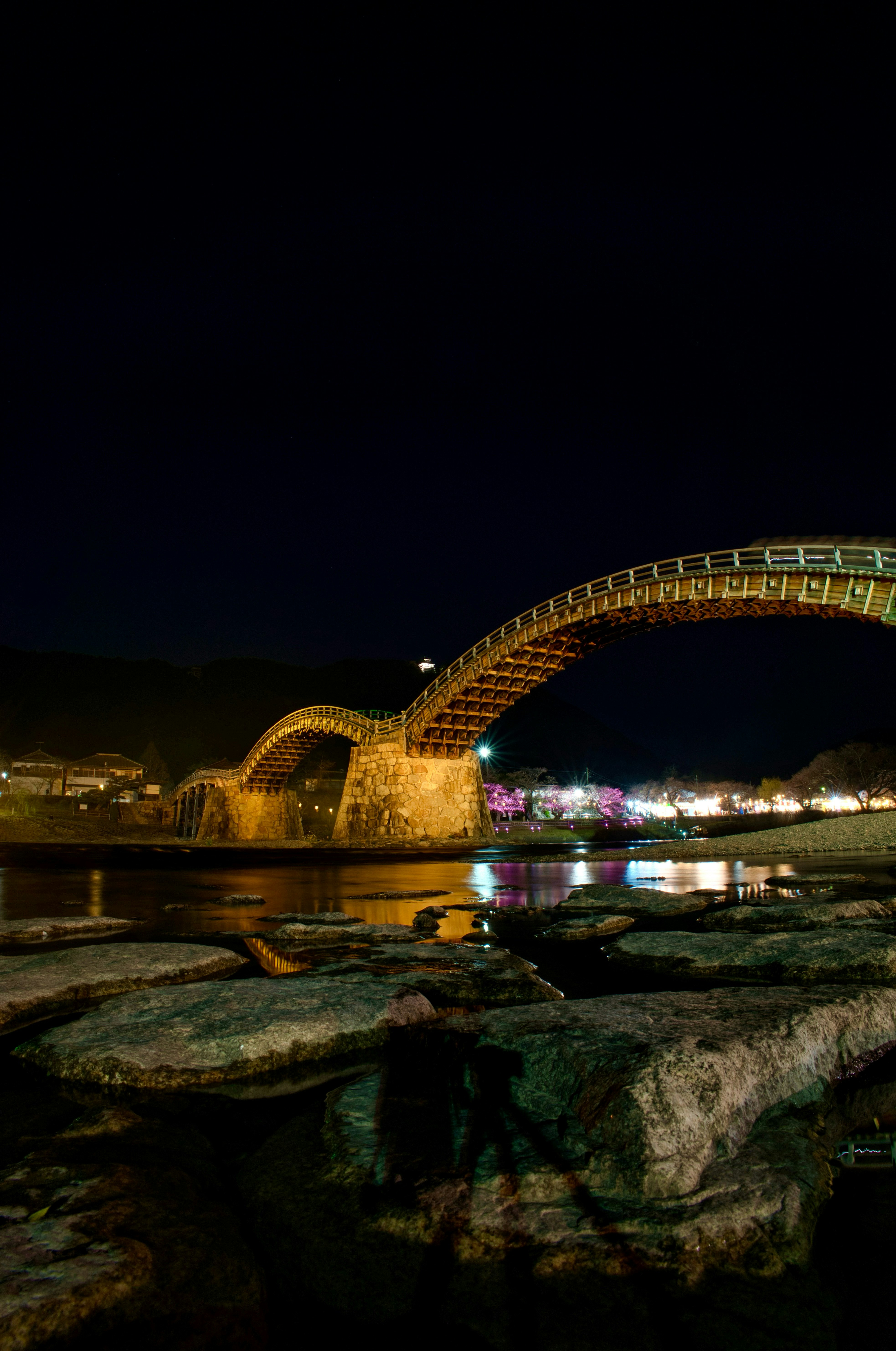 Kintaikyo Bridge illuminated at night with reflections on the river
