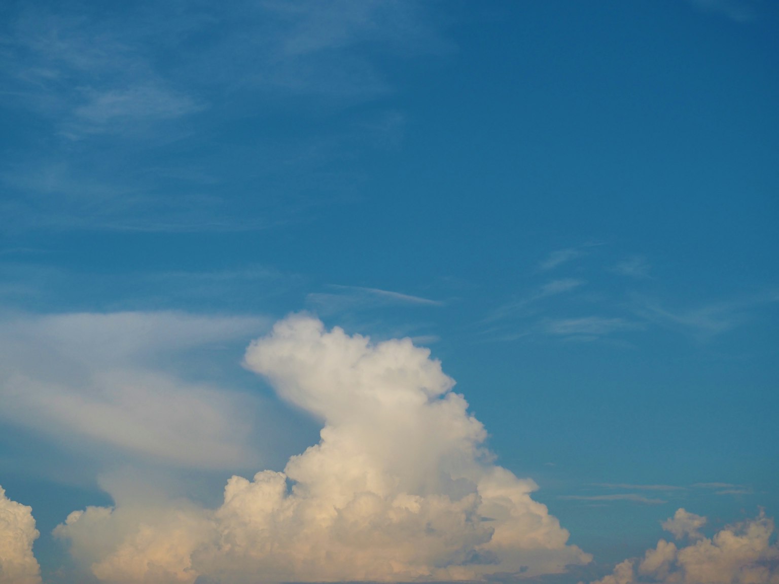 A landscape of white clouds floating in a blue sky
