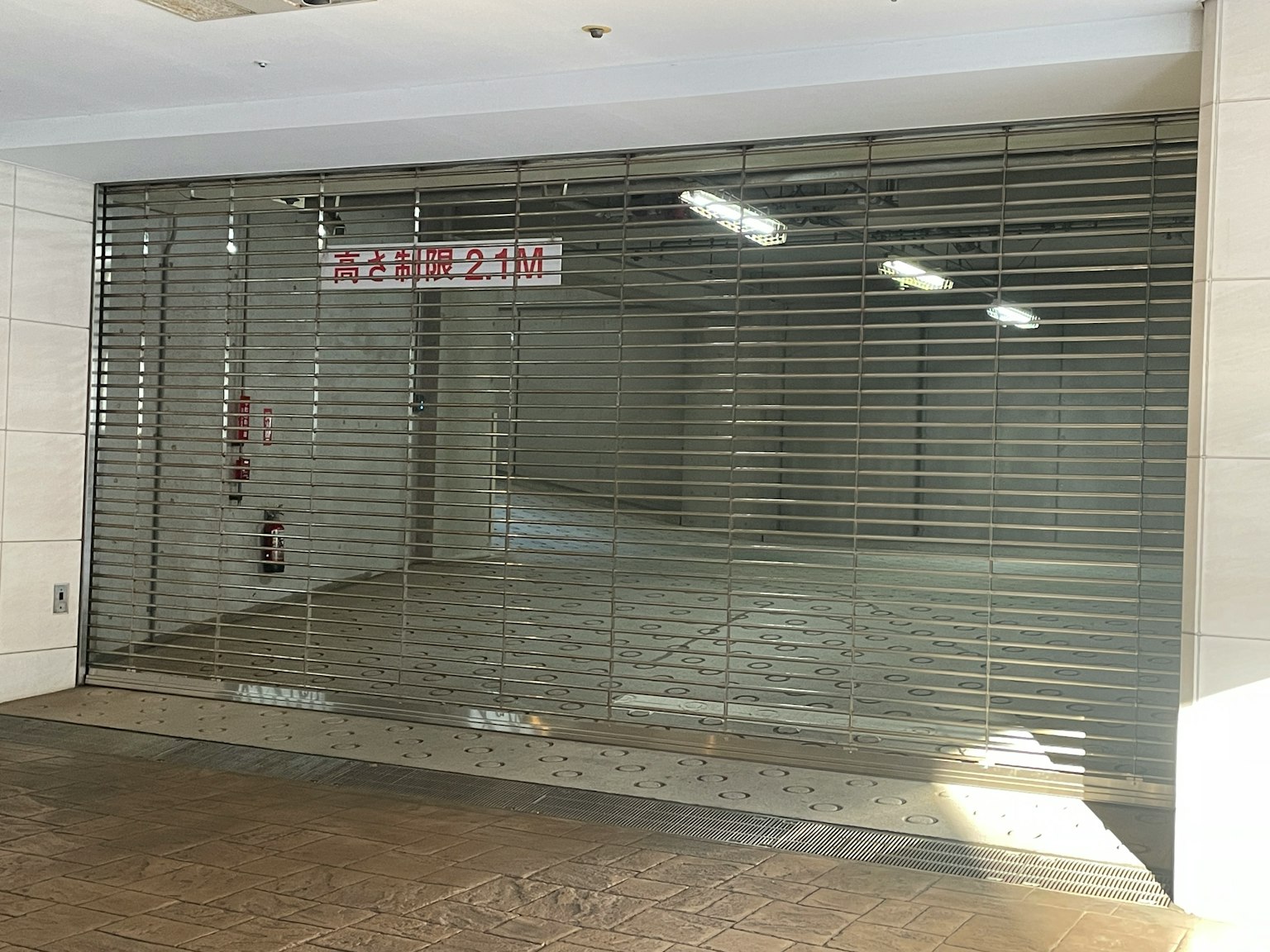 Fachada de tienda cerrada con persiana metálica y cartel