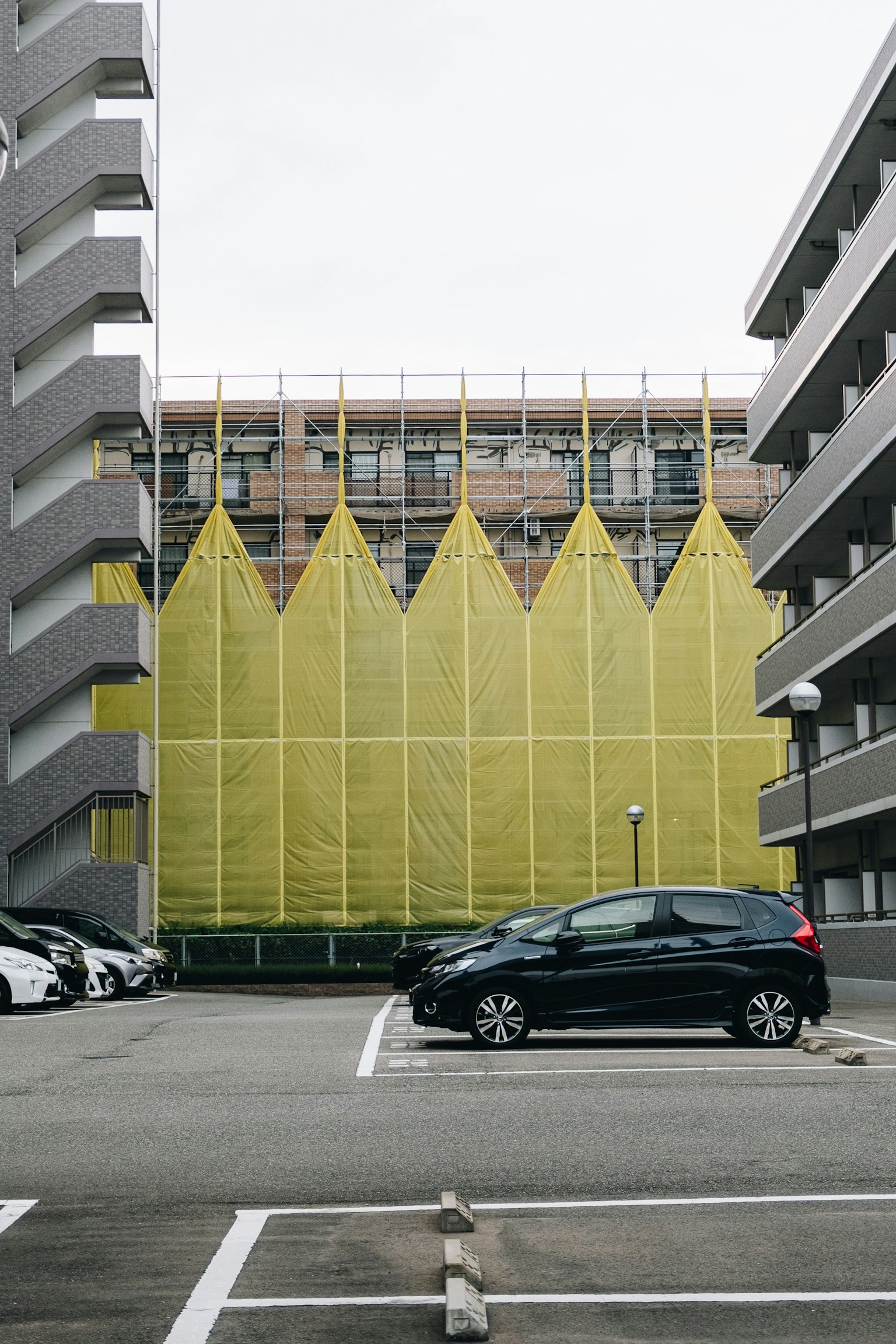 Parkplatzansicht mit einem Gebäude mit gelber dekorativer Fassade