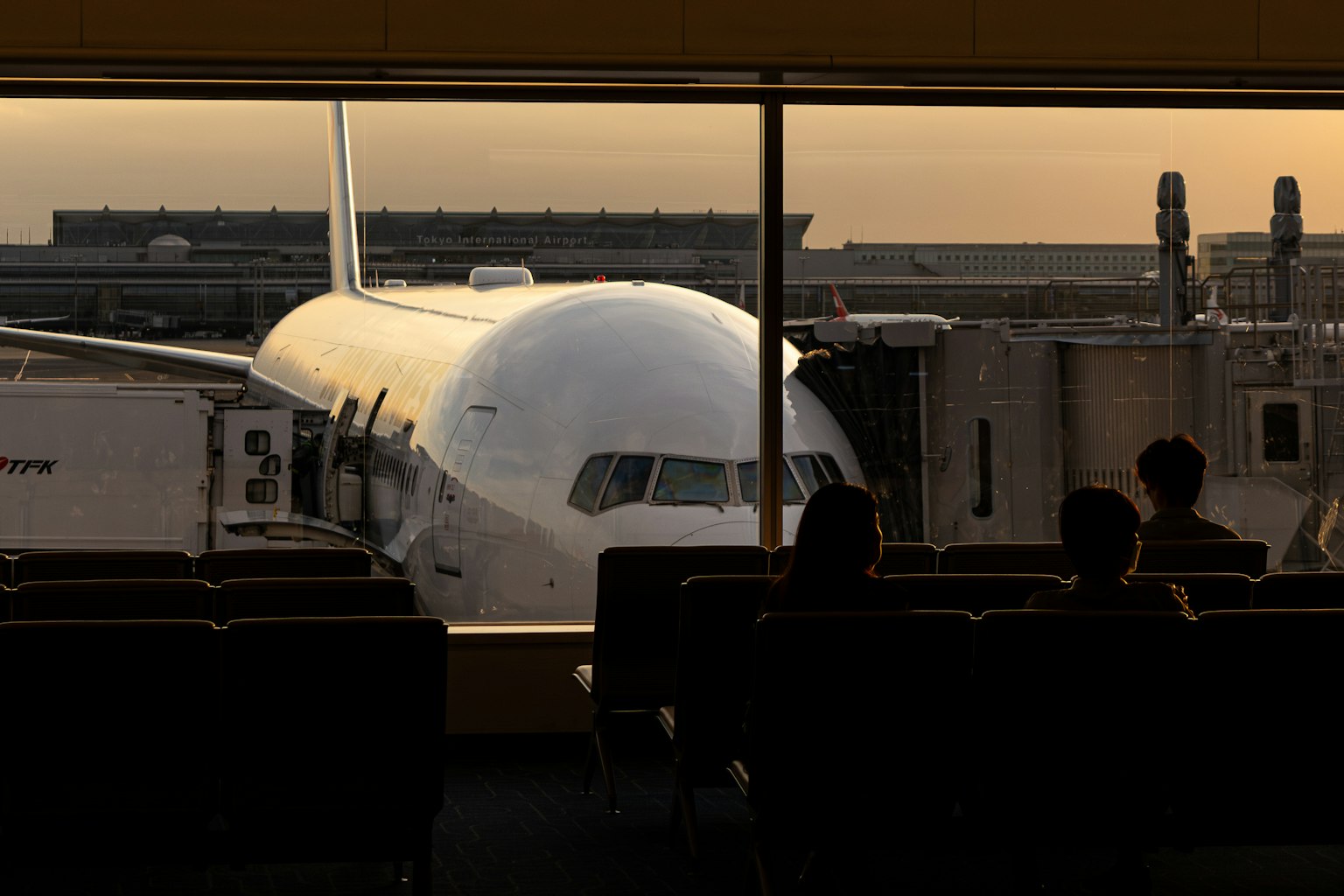 空港のラウンジから見える飛行機と夕日