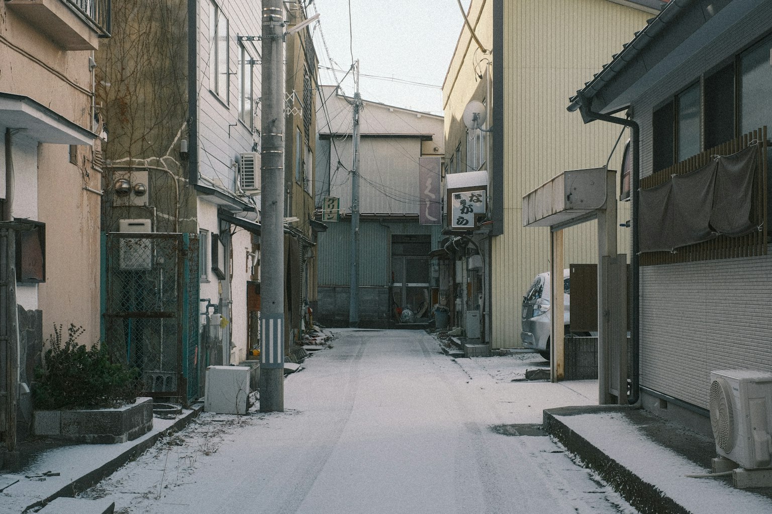 Quiet alley scene with snow-covered ground and old buildings
