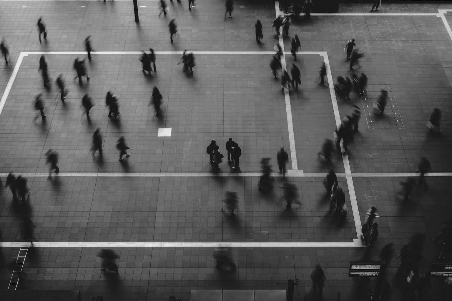 人々が行き交う都市の広場の上からの視点でのモノクロ写真