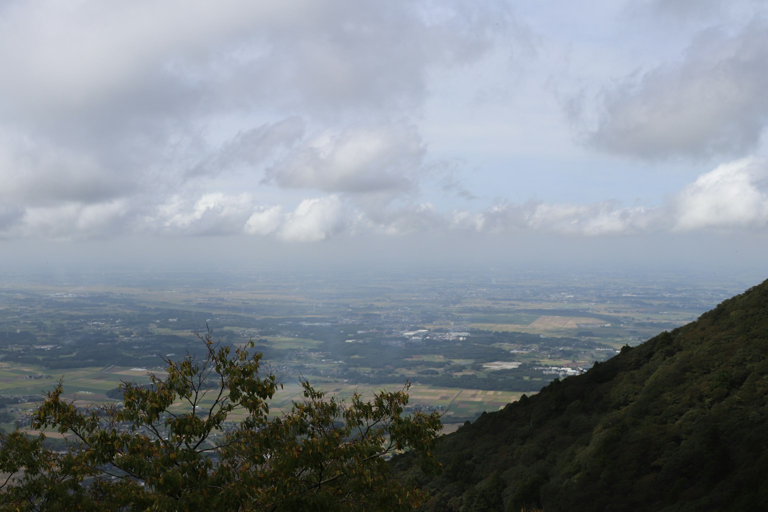 Ampio paesaggio visto da un pendio montano con cielo nuvoloso