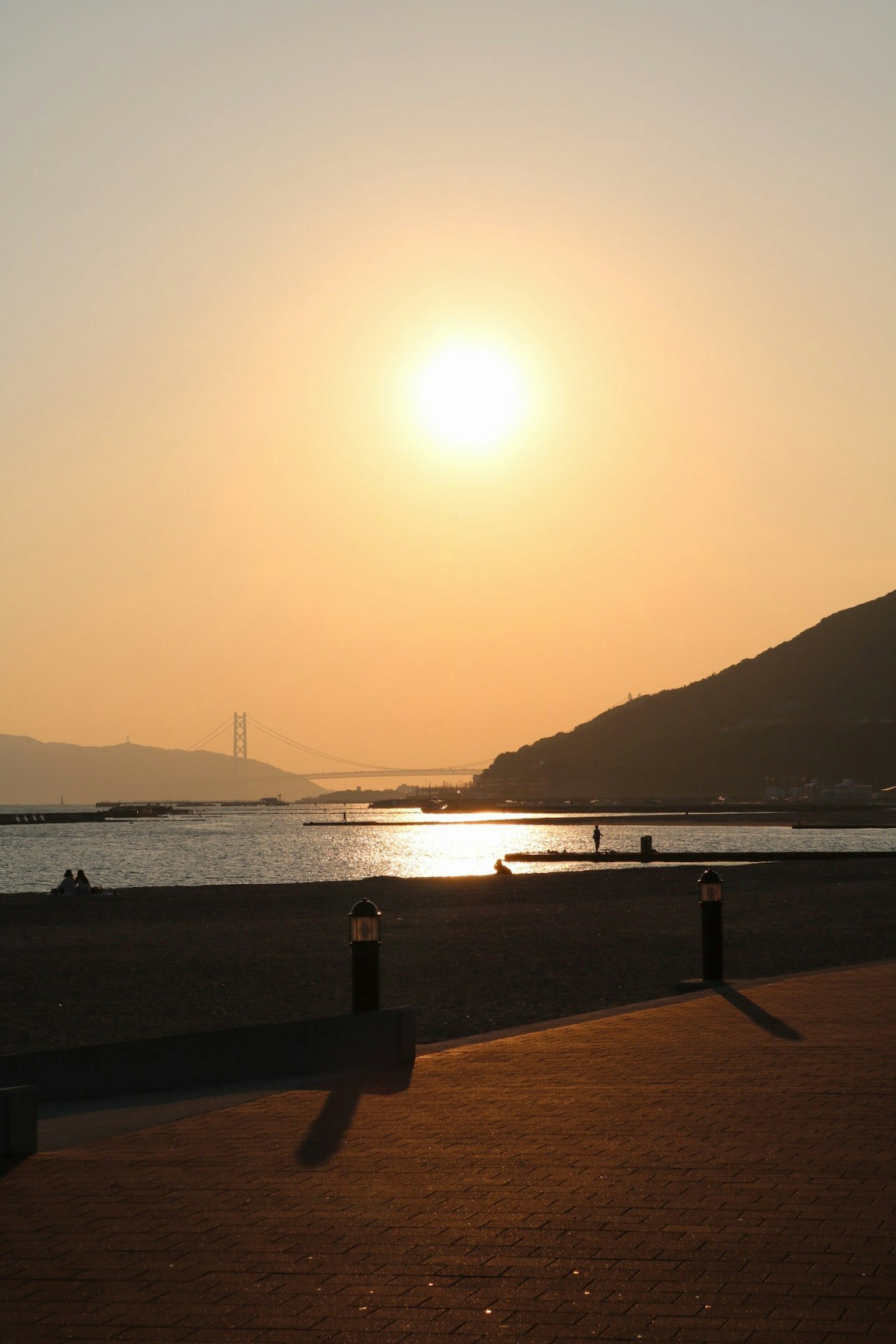Sonnenuntergang über dem Meer mit Bergsilhouette